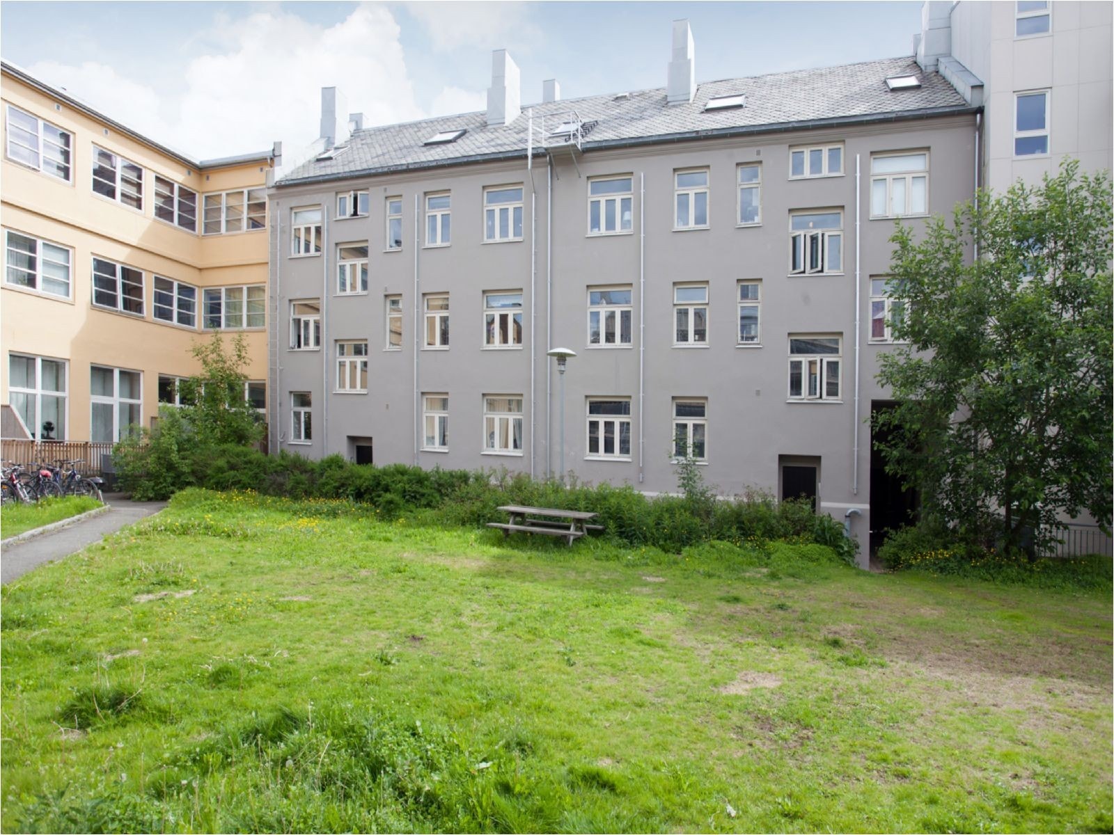 Bakgården har store grøntområder hvor man kan nyte de varme sommerdagene i solen Galleribilde