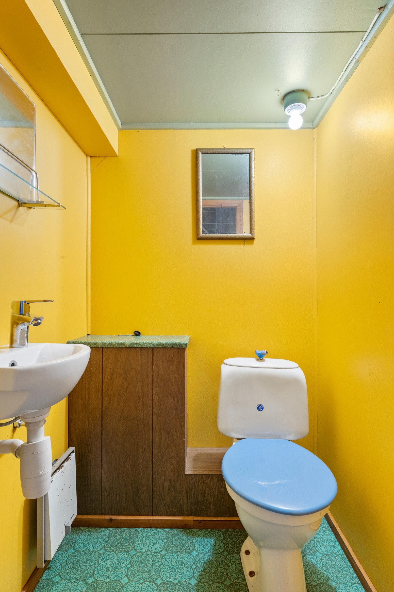 Toalettrom i kjelleretasje med malte vegger og belegg på gulv. Badet er innredet med baderomsinnredning og toalett. Galleribilde