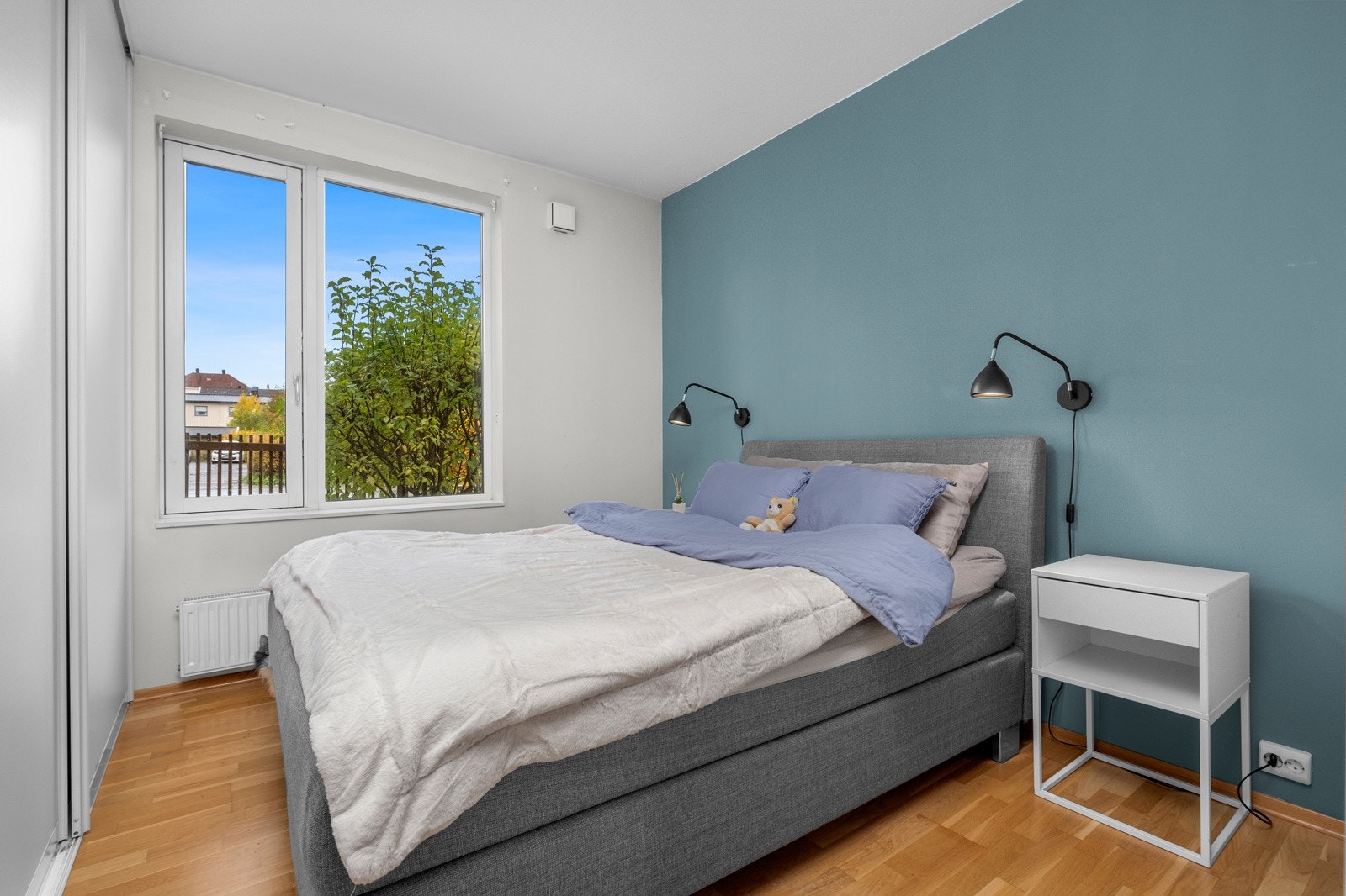 Stort og lyst hovedsoverom med skyvedørsgarderobe Galleribilde