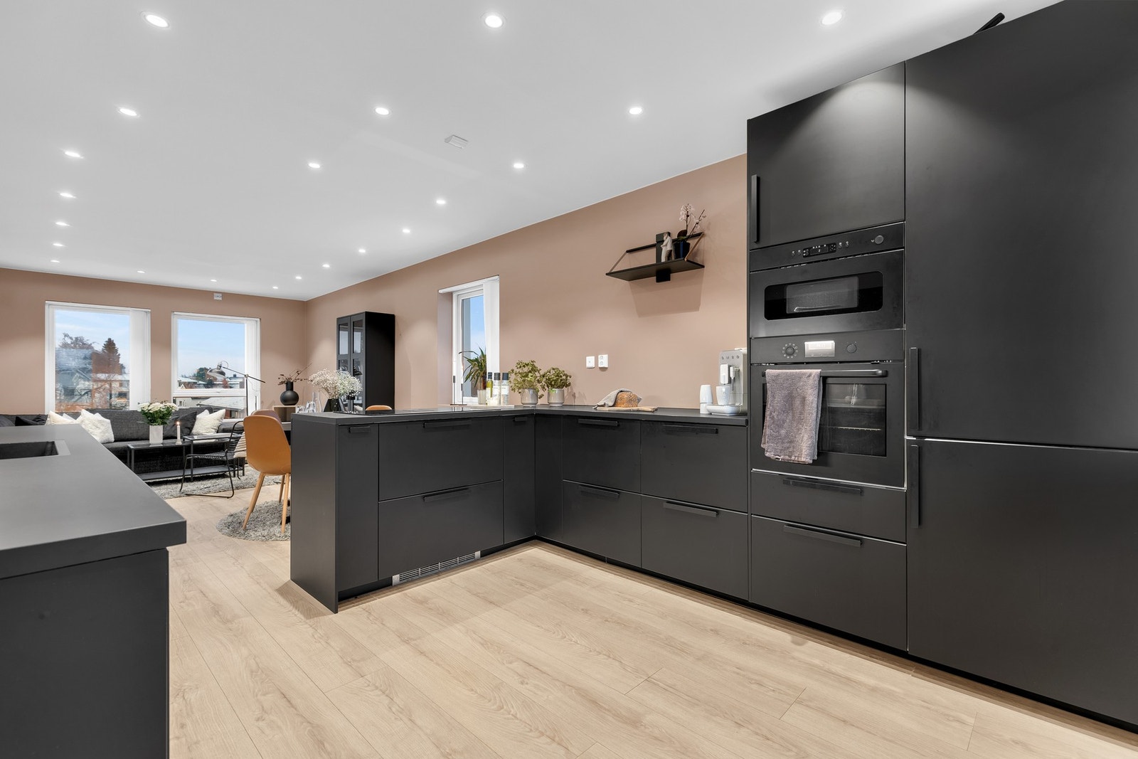 Kjøkkenet har et minimalistisk preg med gulldetaljer og sorte hvitevarer, samt store og godt belyste arbeidsflater. Galleribilde