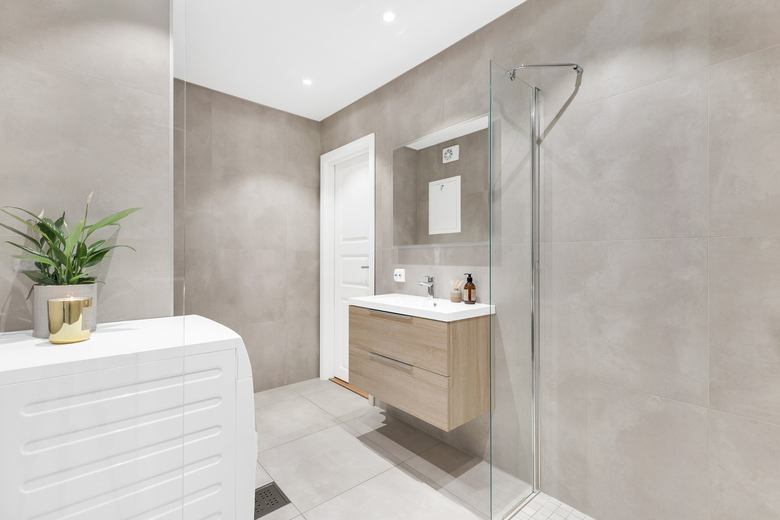 Badet har downlights i taket, flislagte overflater og varmekabler i gulvet. Galleribilde