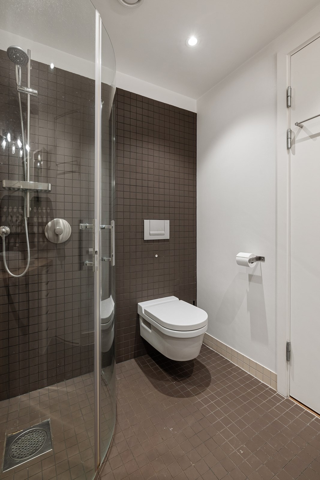 Baderommet inneholder veggmontert toalett, servant, speil, belysning og dusjhjørne. Galleribilde