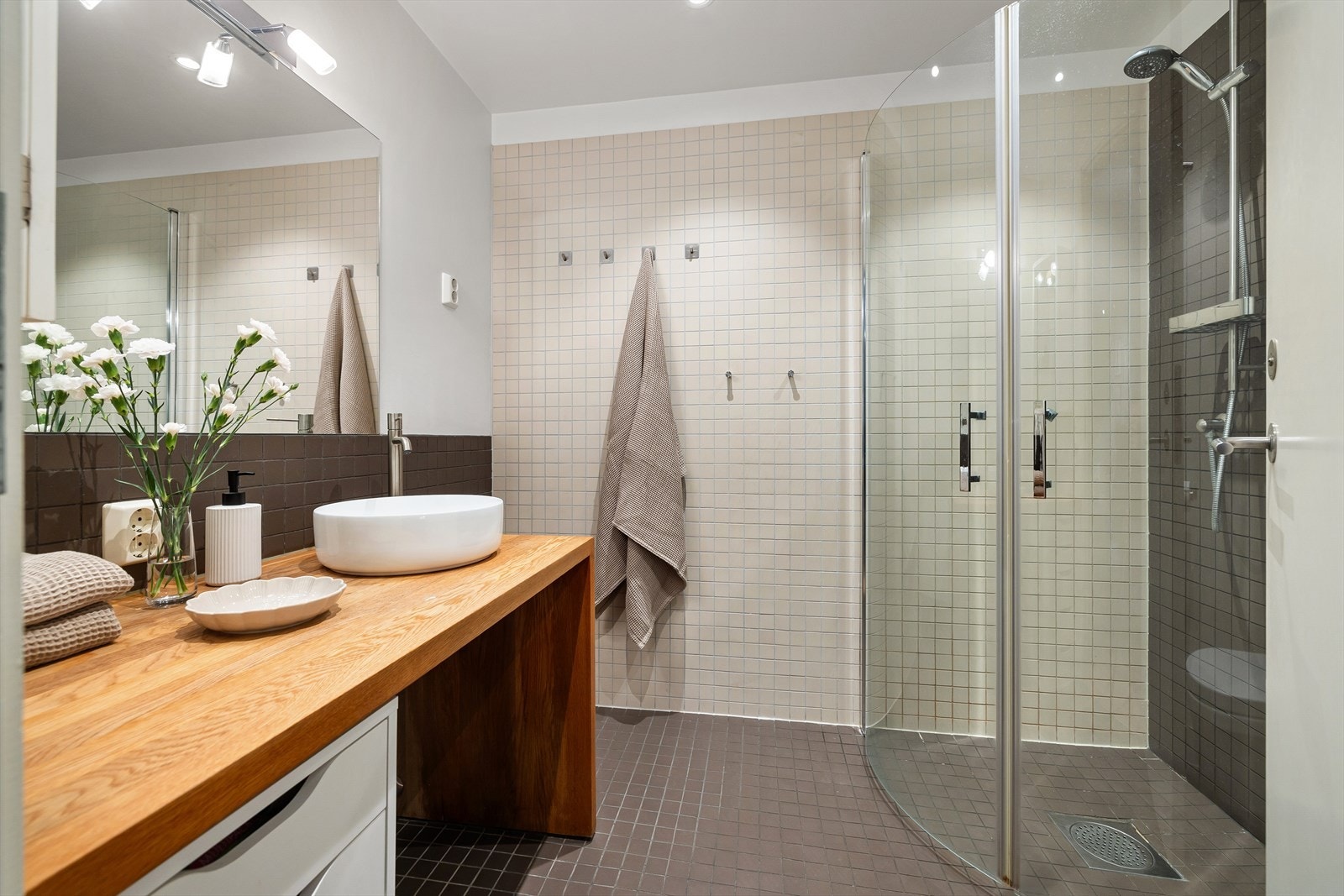 Velfungerende og tidløst bad fra byggeår med flislagte overflater, behagelig gulvvarme og downlights i himling. Galleribilde