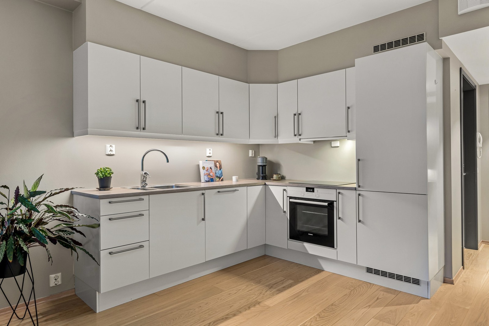 Kjøkkenet fremstår moderne og tidløst med en lys fargetone på fronter. Kjøkkenet har flotte og praktiske detaljer som glassplater mellom over- og underskap. Galleribilde