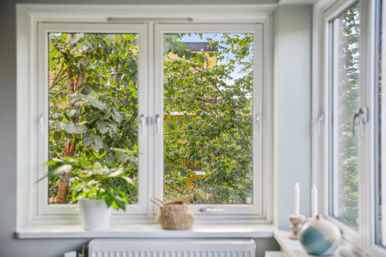 Leiligheten har store vindusflater med frodig og grønt utsyn. Galleribilde