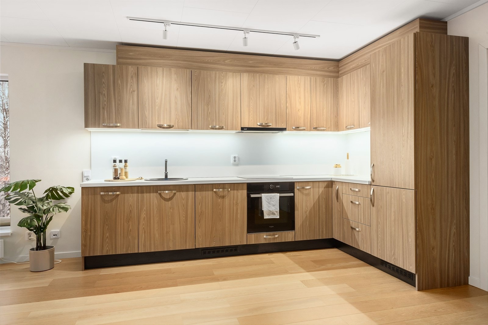 Kjøkkenet har moderne uttrykk med finerte slette fronter og laminert benkeplate. Galleribilde