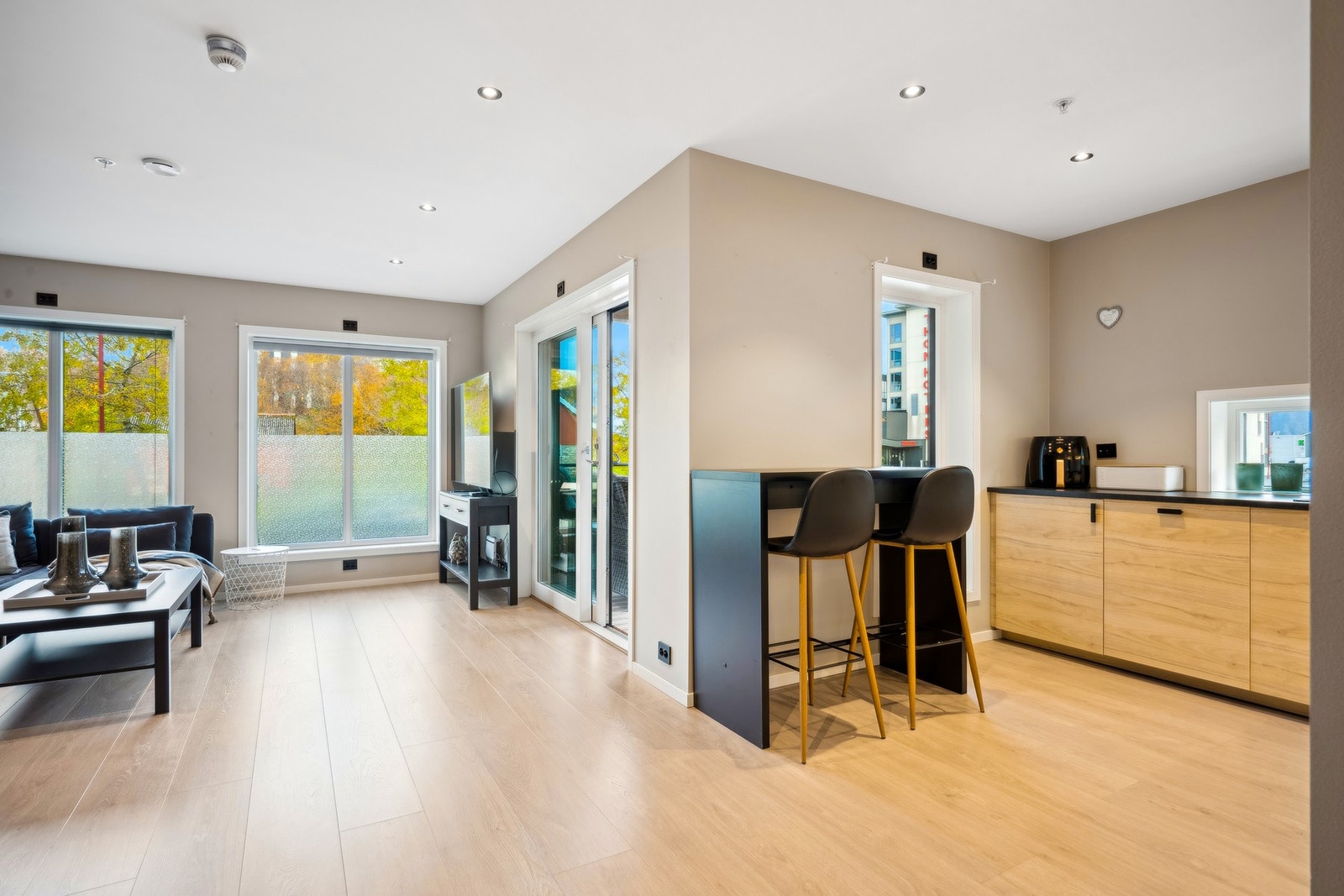 Åpen løsning mellom kjøkken og stue er perfekt for sosialt samvær og en funksjonell hverdag. Galleribilde