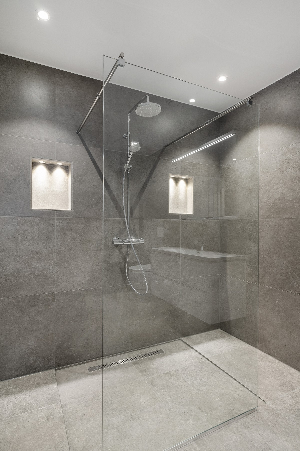 Flislagt bad i hovedetasje med delikat dusjnisjé Galleribilde