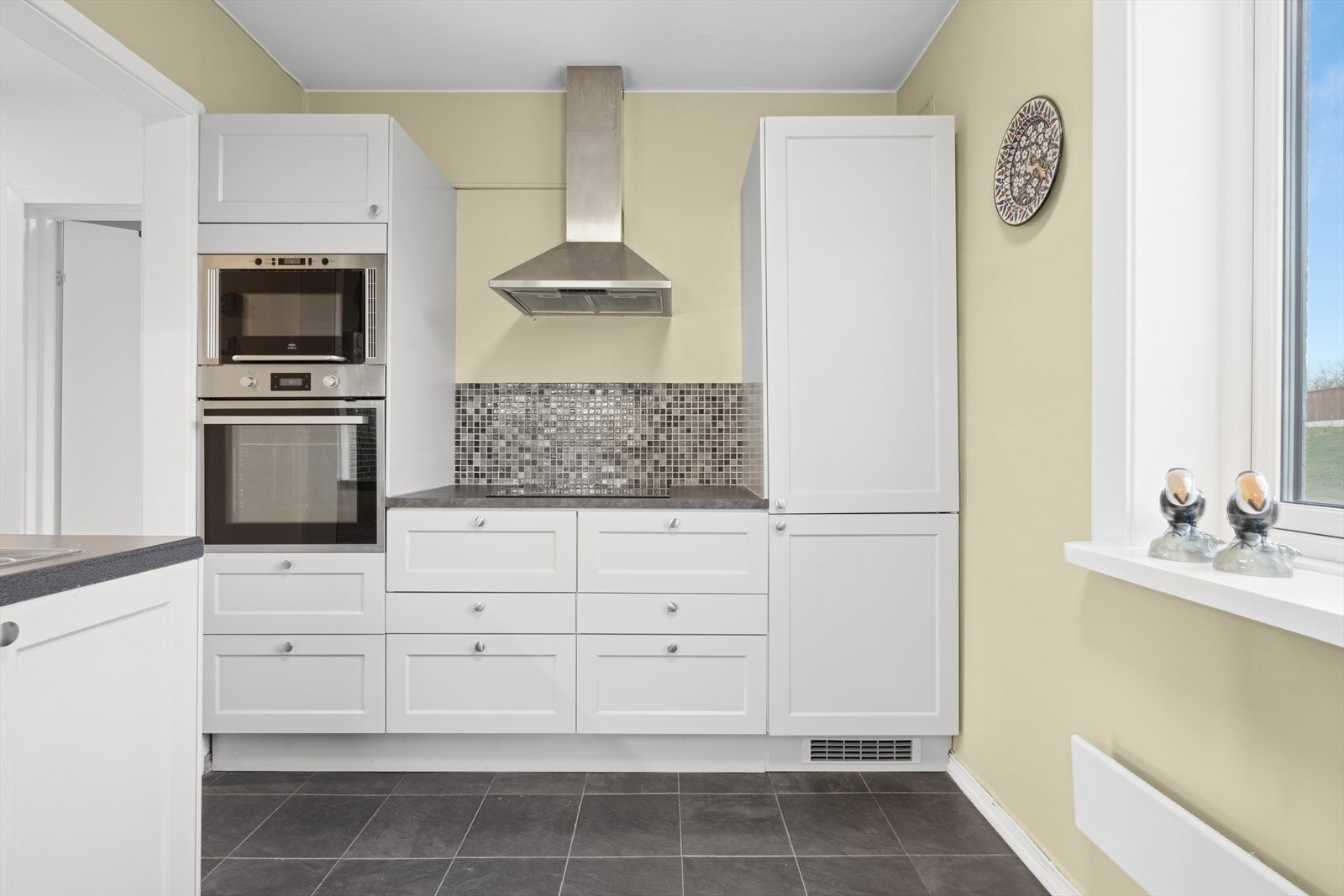 Kjøkkeninnredningen består av tidløse, profilerte fronter og laminat benkeplate. Galleribilde