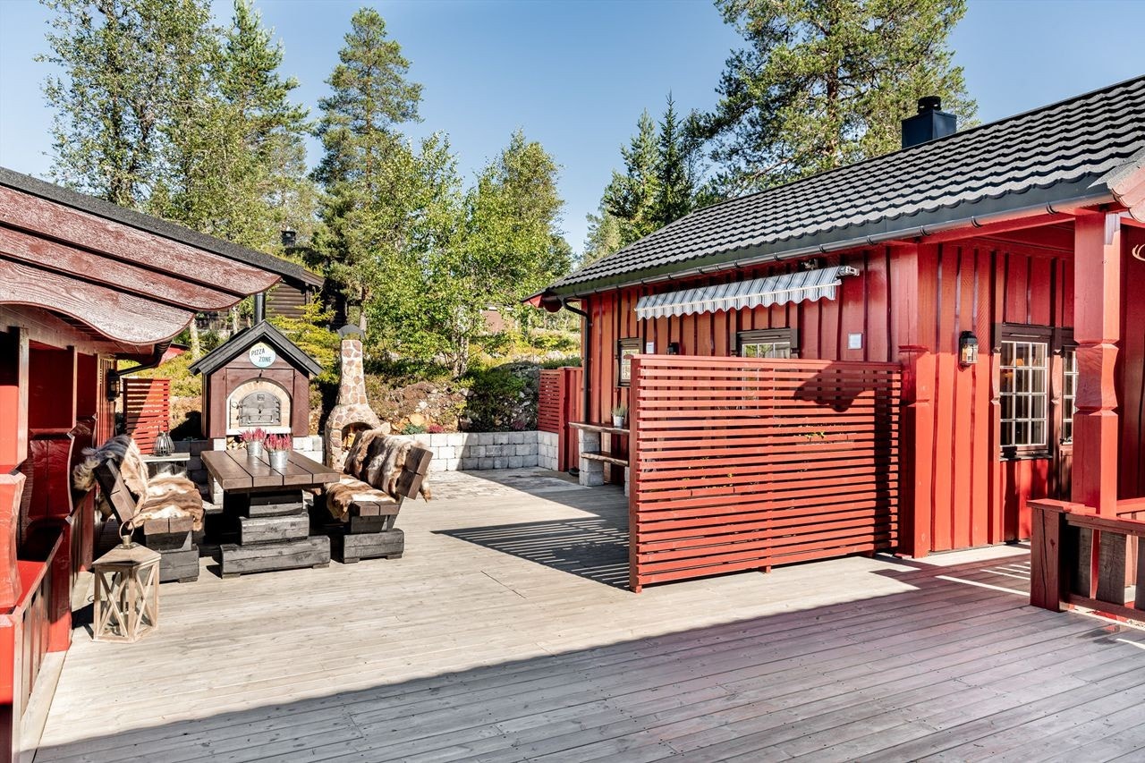 Fine uteplasser, her med lun platting. Noe av uteplassen er steinlagt og har pizzaovn og murt utepeis. Levegg og markise. Galleribilde