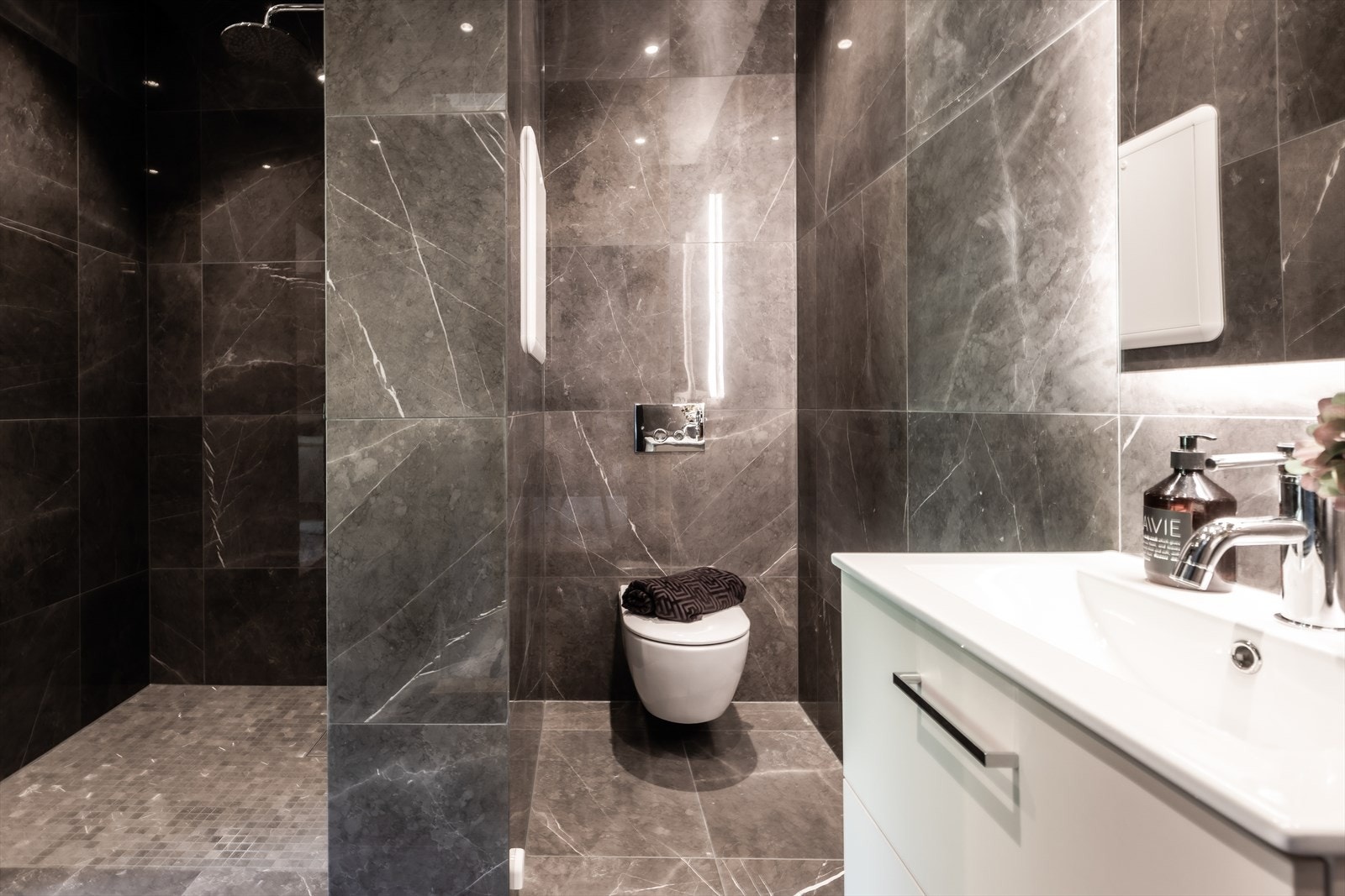 Lekkert, helfliset bad med pene overflater, elektriske varmekabler og downlightsbelysning Galleribilde