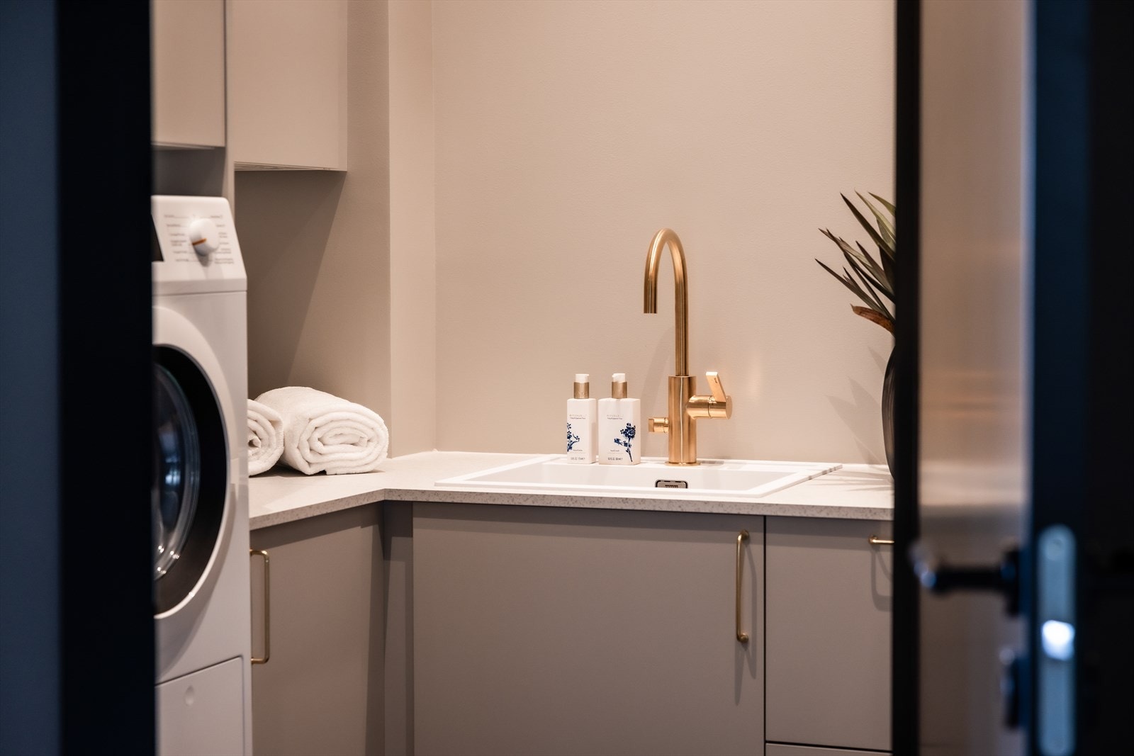 Praktisk, separat vaskerom med flislagt gulv, elektriske varmekabler og downlightsbelysning Galleribilde