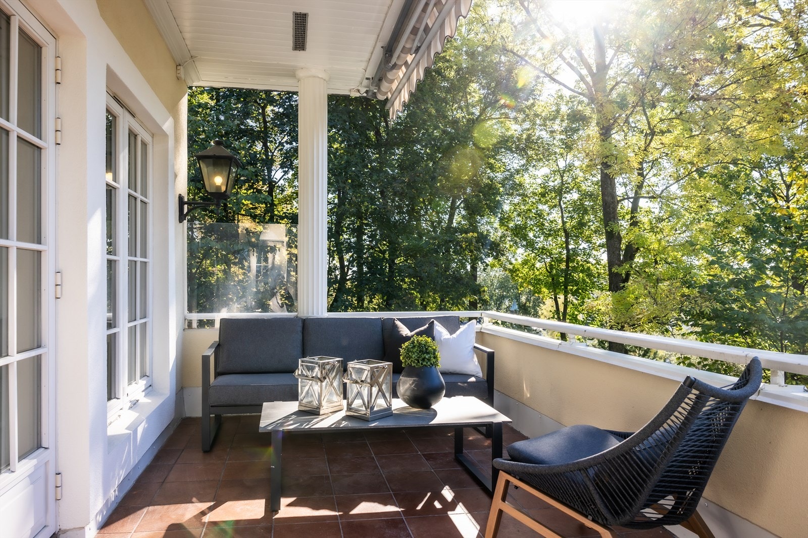 Fra stuen er det utgang til en solrik terrasse med flislagt gulv, markise og utebelysning Galleribilde