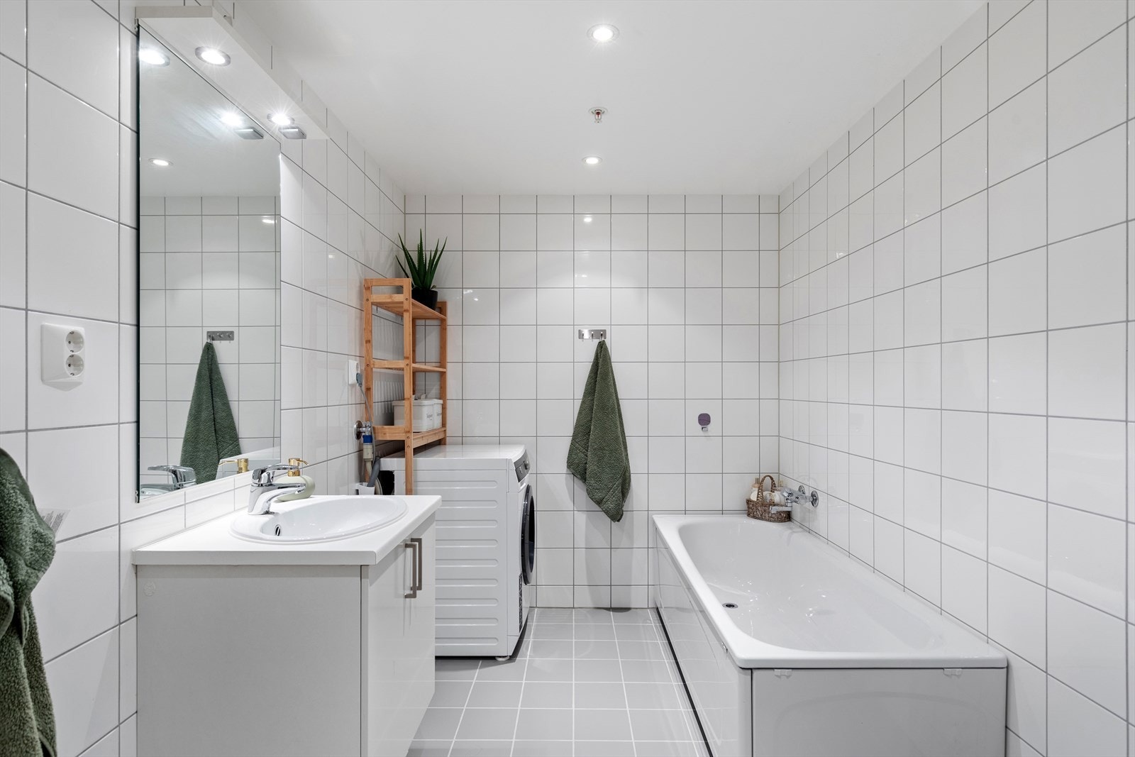 Et svært pent bad/vaskerom med varmekabler i gulvet for ekstra komfort. Rommet er utstyrt med servant, vegghengt toalett og badekar. Galleribilde