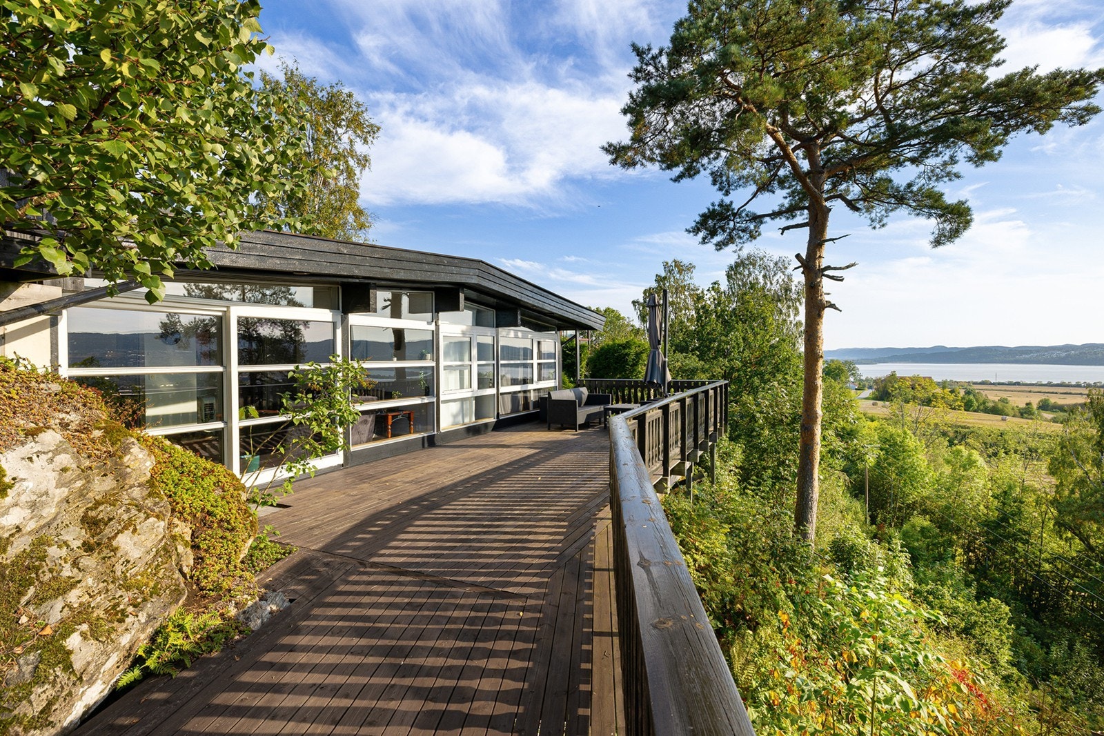 En stor skyvedør fører ut til en balkong med tregulv på 44 kvm med flott utsikt. Galleribilde