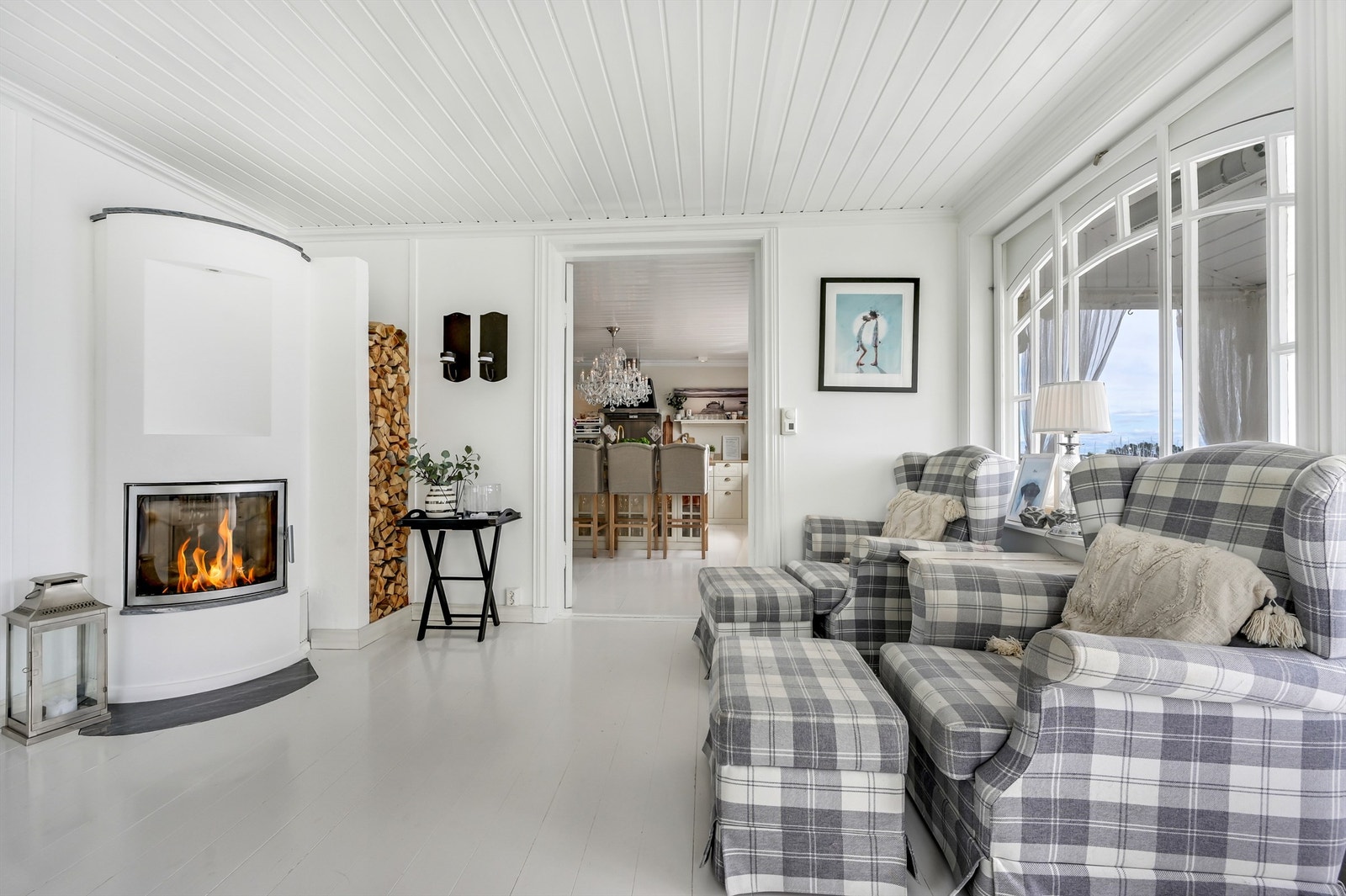 Den innbydende stuen prydes av en vakker peisovn og nydelig vindussetting på 2 sider og har utgang til veranda og til det fantastiske utomhus området. Galleribilde