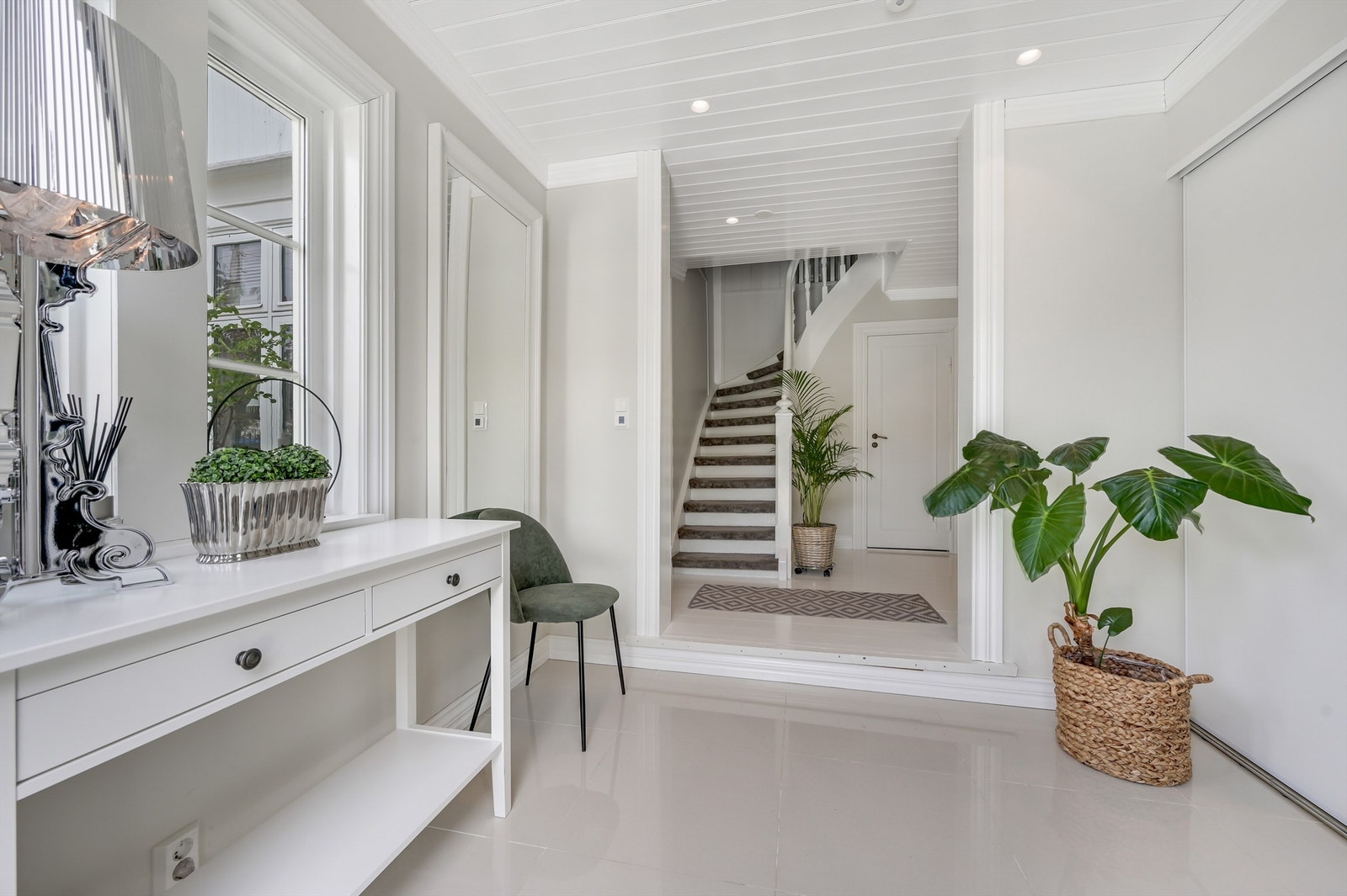 Man kommer videre i en trappehall med tilkomst til øvre etasje, bad/vaskerom på den ene siden og tilkomst til spisestue, kjøkken og stue. Galleribilde