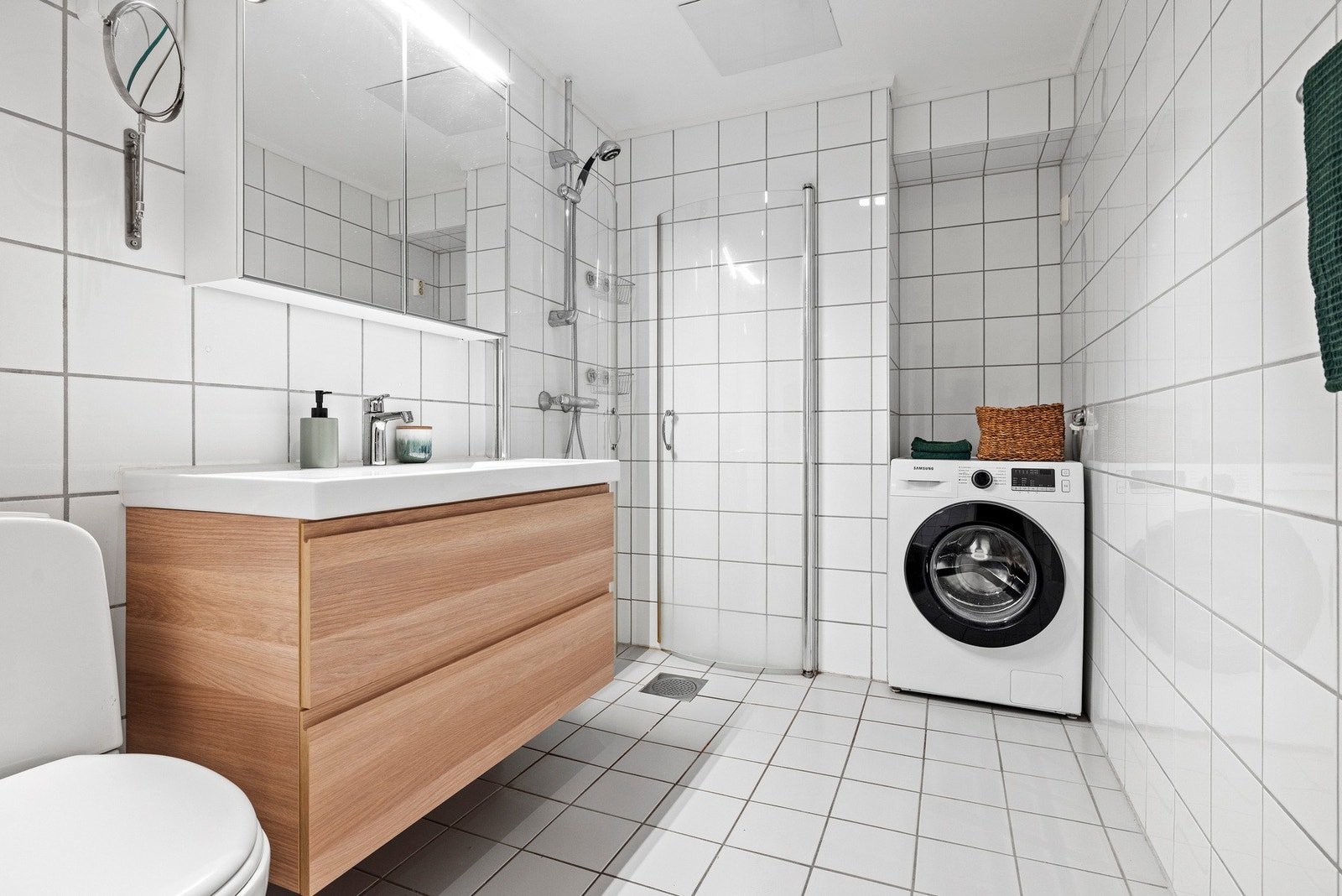 Romslig og flislagt baderom med praktisk dusjhjørne og opplegg for vaskemaskin. Her får du fint plass til tørketrommel. Galleribilde