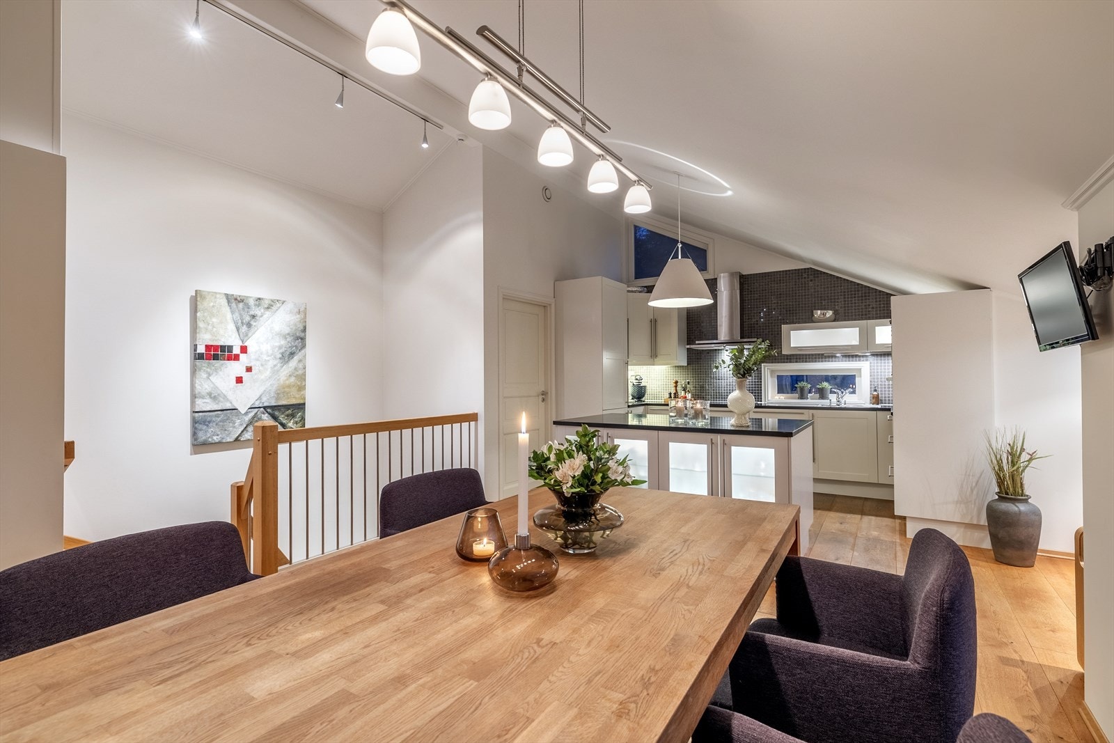 Smakfullt kjøkken med lys innredning med profilerte fronter, fliser på vegg over kjøkkenbenk og granitt benkeplate. Galleribilde