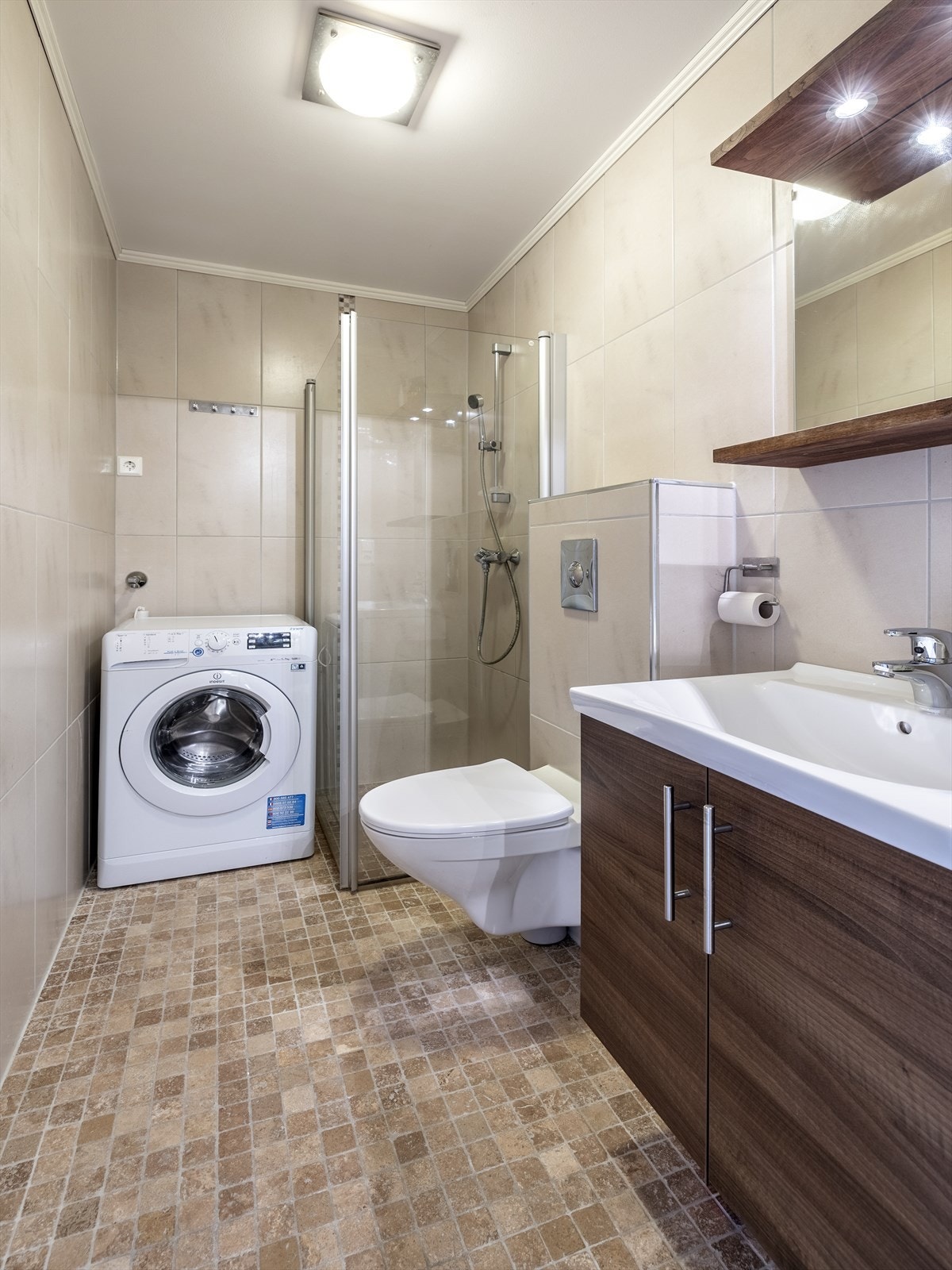 Badet har flislagte overflater, downlights i himling og gulvvarme. Galleribilde