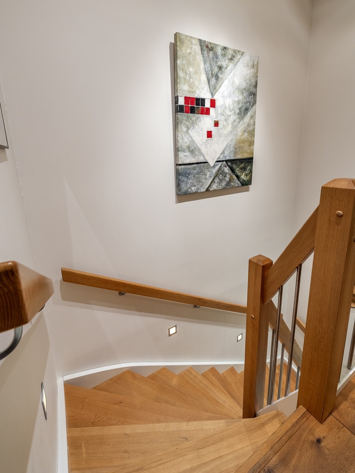 Eiketrapp med hvite vanger og stålspiler. Vegglys. Galleribilde