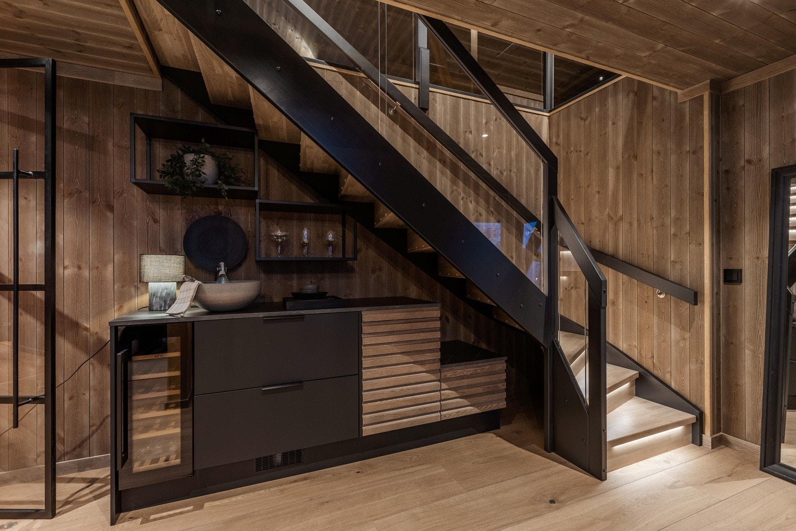 Under trappen er det installert møbel med benkeplate og integrert vinskap med plass for 20 flasker og seksjon med to kjøleskuffer med temperaturregulering. Galleribilde