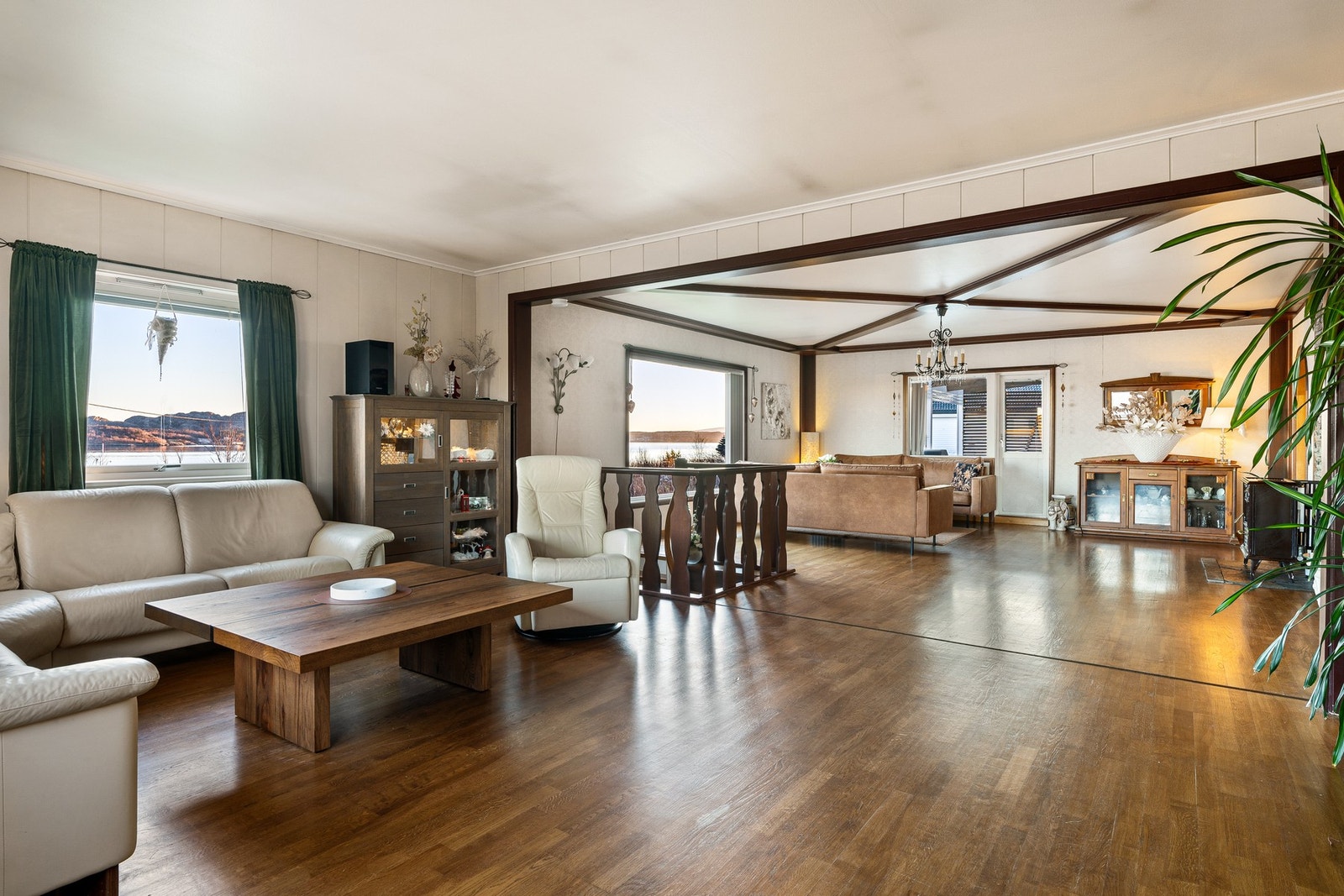 Stuen har store vindusflater som tilfører rommet rikelig med naturlig lys Galleribilde