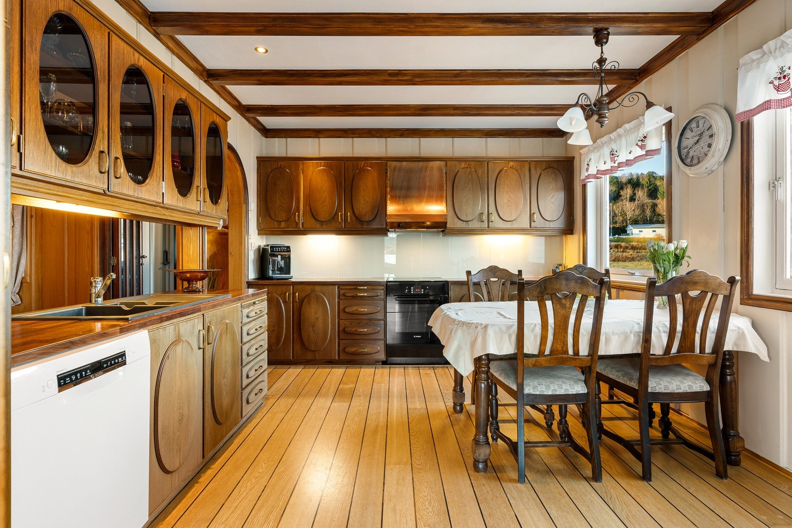 Solid heltre kjøkkeninnredning som byr på godt med skap- og benkeplass Galleribilde