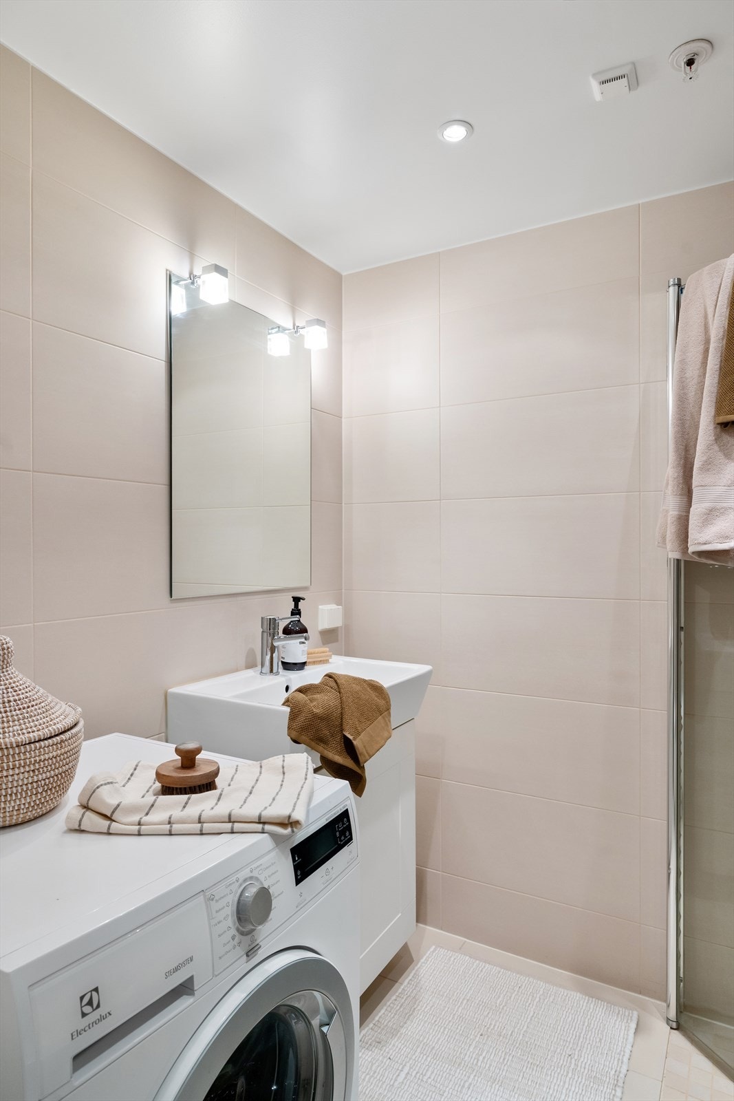 Veggmontert wc, servantskap med speil over og armatur fra Damixa - opplegg og plass for både vaskemaskin og tørketrommel Galleribilde