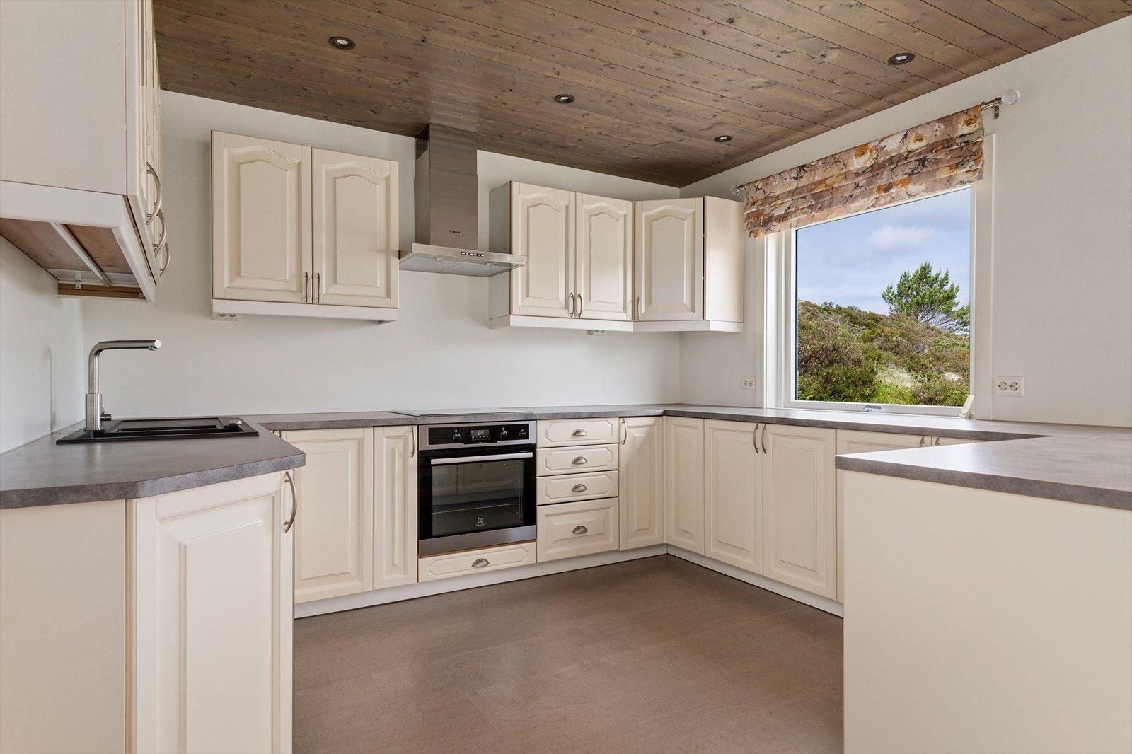 Kjøkkeninnredning fra Skeide Møbelindustri med profilerte fronter og laminat benkeplate med nedfelt vask og platetopp | integrert stekeovn Galleribilde