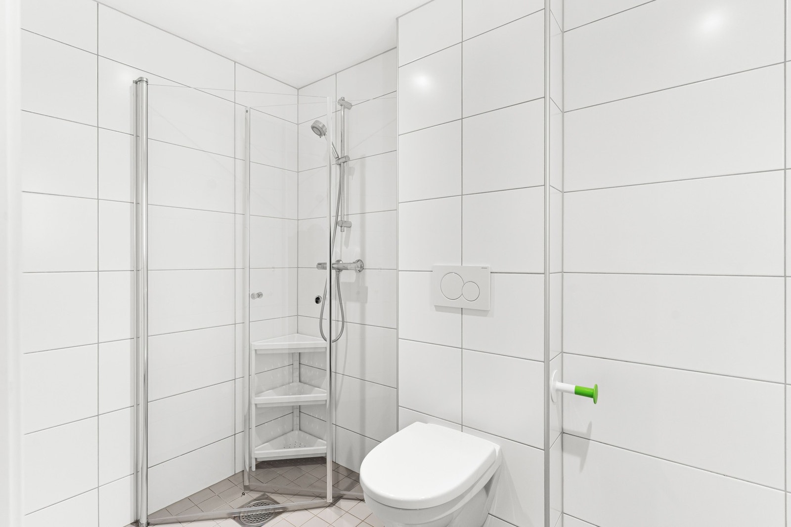 Baderomsinnredningen er bestående av vegghengt servantskap med glatte fronter, nedsenket servant med ett-greps armatur, vegghengt speilskap med integrert lys, dusjhjørne med innfellbare glassdører og dusjarmatur tilkoblet hånddusj. I tillegg er det vegghe Galleribilde