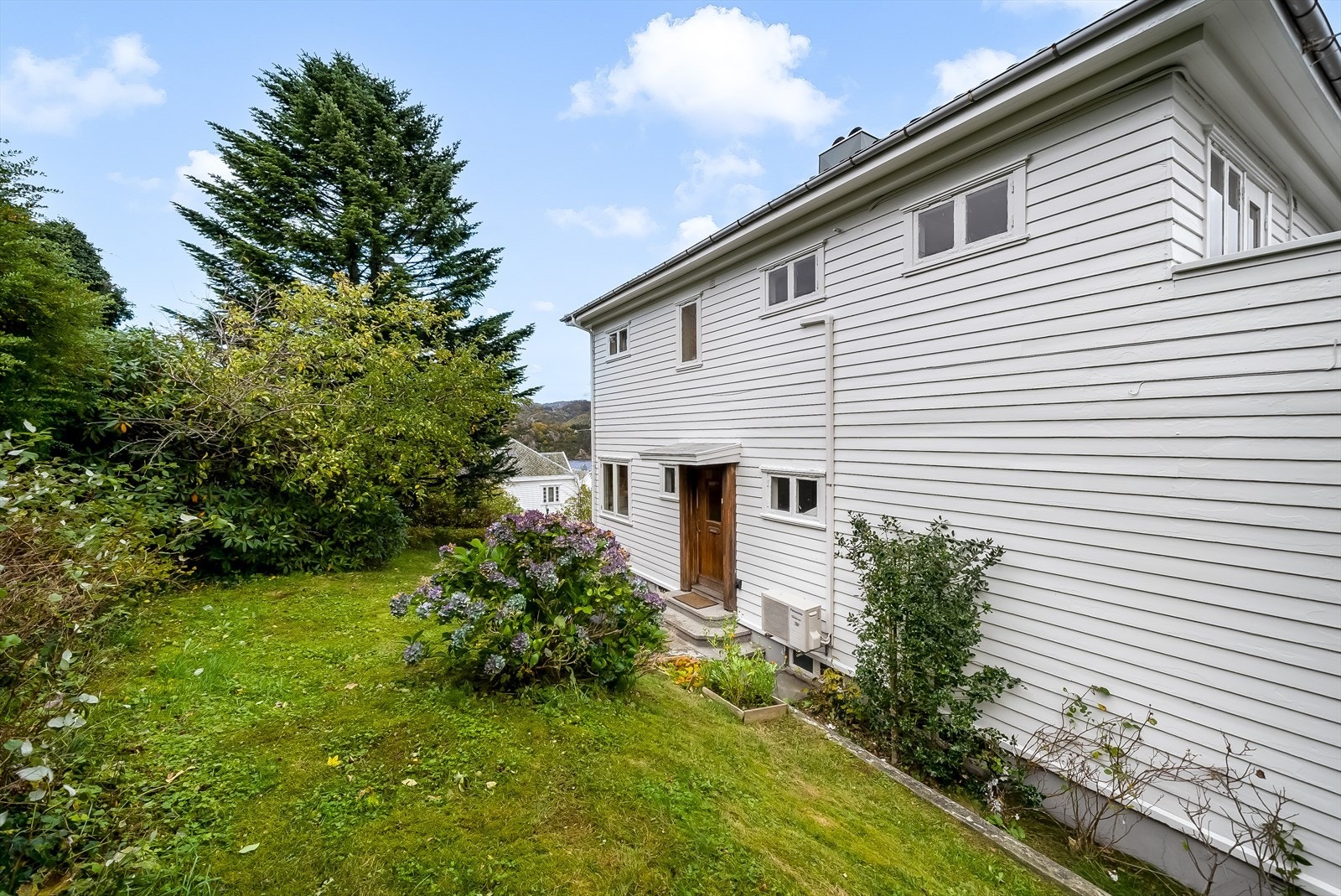 Inngangspartiet ligger bak boligen. Her er en bakhage med stort potensiale. Galleribilde