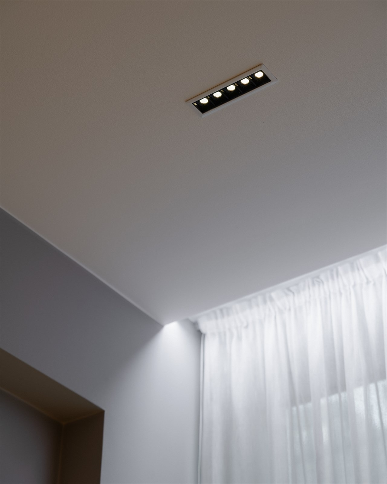 Taket er nedsenket med spesialbelysning. Det er også lagt opp lyslist langs gardinopphenget ved vinduet. Galleribilde