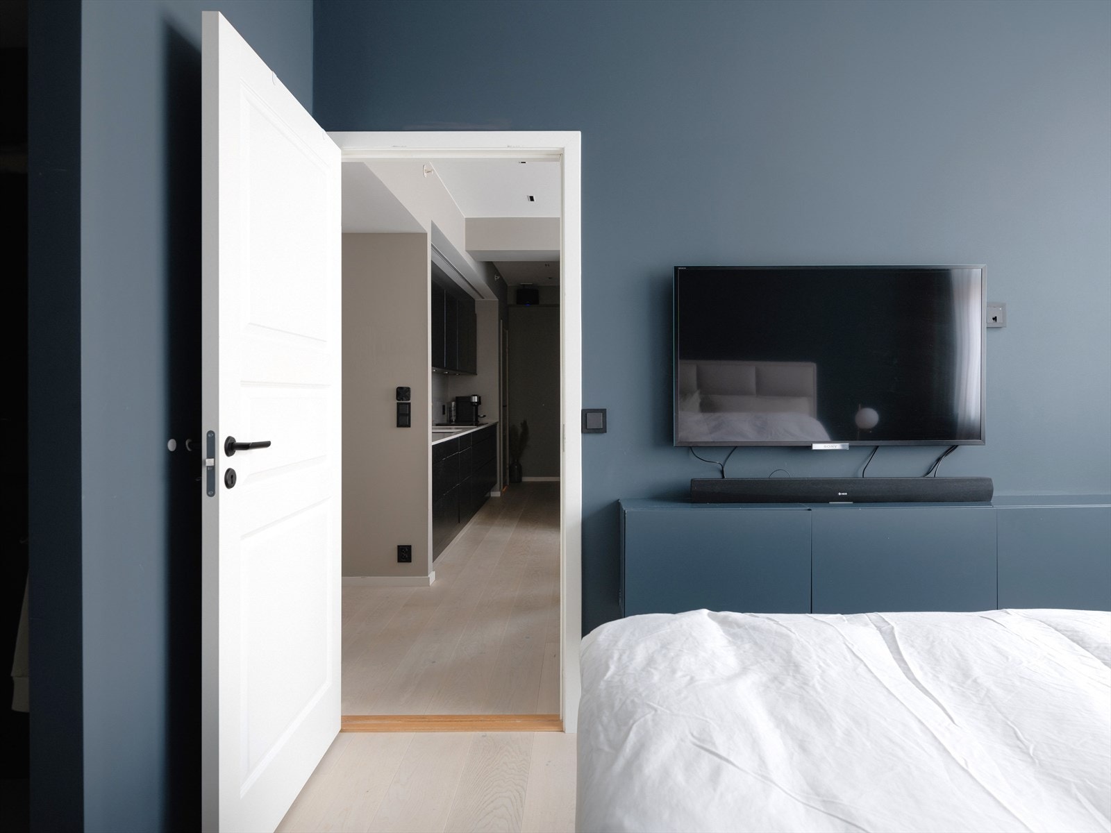 TV-møbel malt i samme fargre som veggen så møblementet nærmest "smelter" inn i veggen. Opplegg for TV på både hovedsoverom, spisestue og stue. Galleribilde