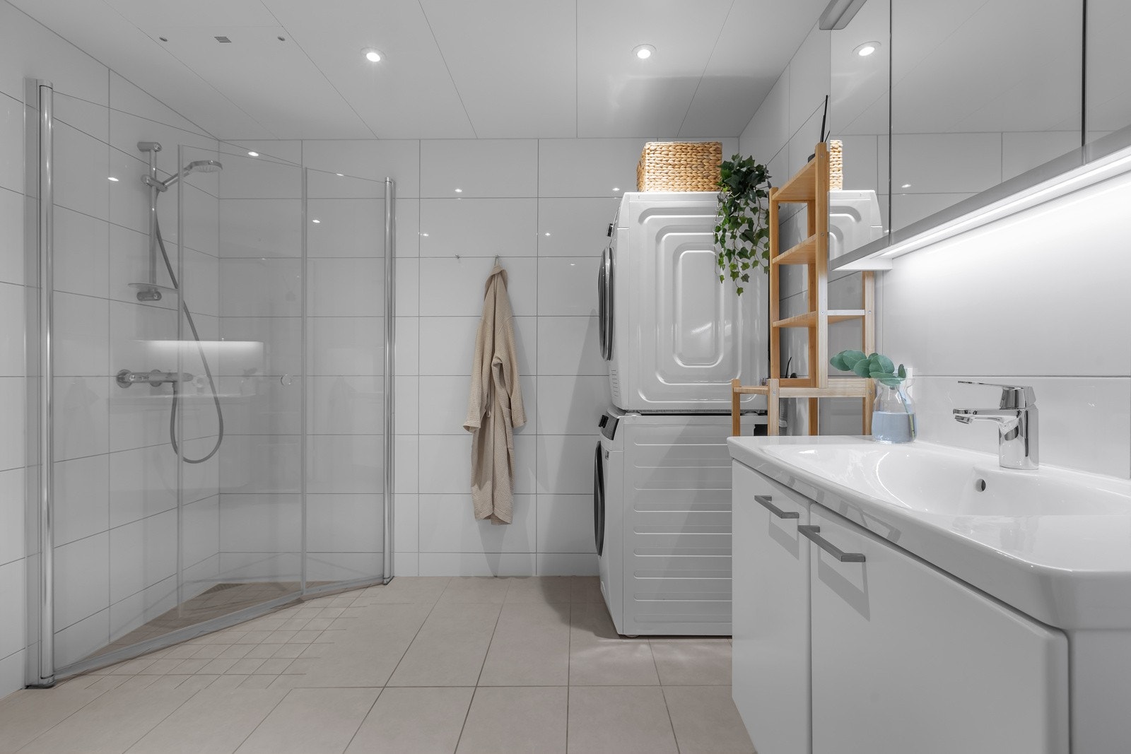 Innredning med heldekkende servant og lagring i både underskap og speilskap. Opplegg for vaskemaskin og tørketrommel. Innfellbare glassdører i dusjsonen. Innfelt takbelysning Galleribilde