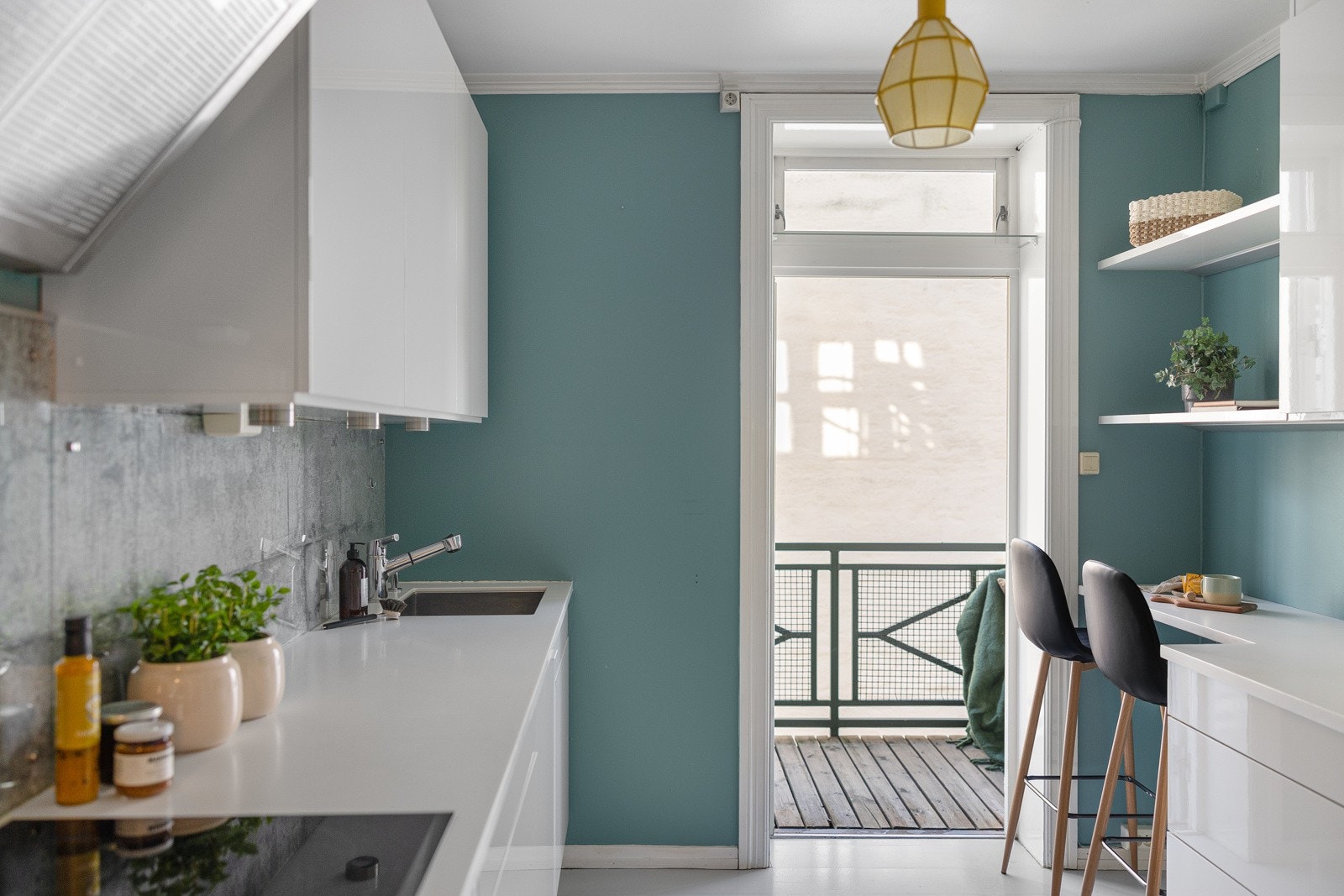 Kjøkkeninnredning med høyglans fronter og glassplate over benk. Galleribilde