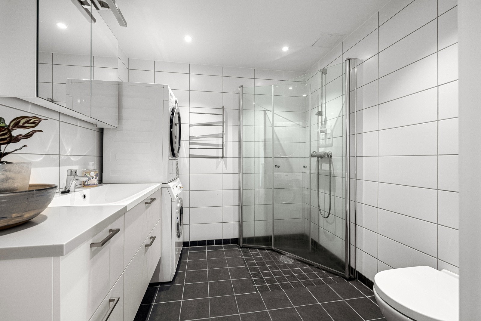 Moderne og stilrent bad med flislagt gulv og vegger, samt downlight i himling. Galleribilde