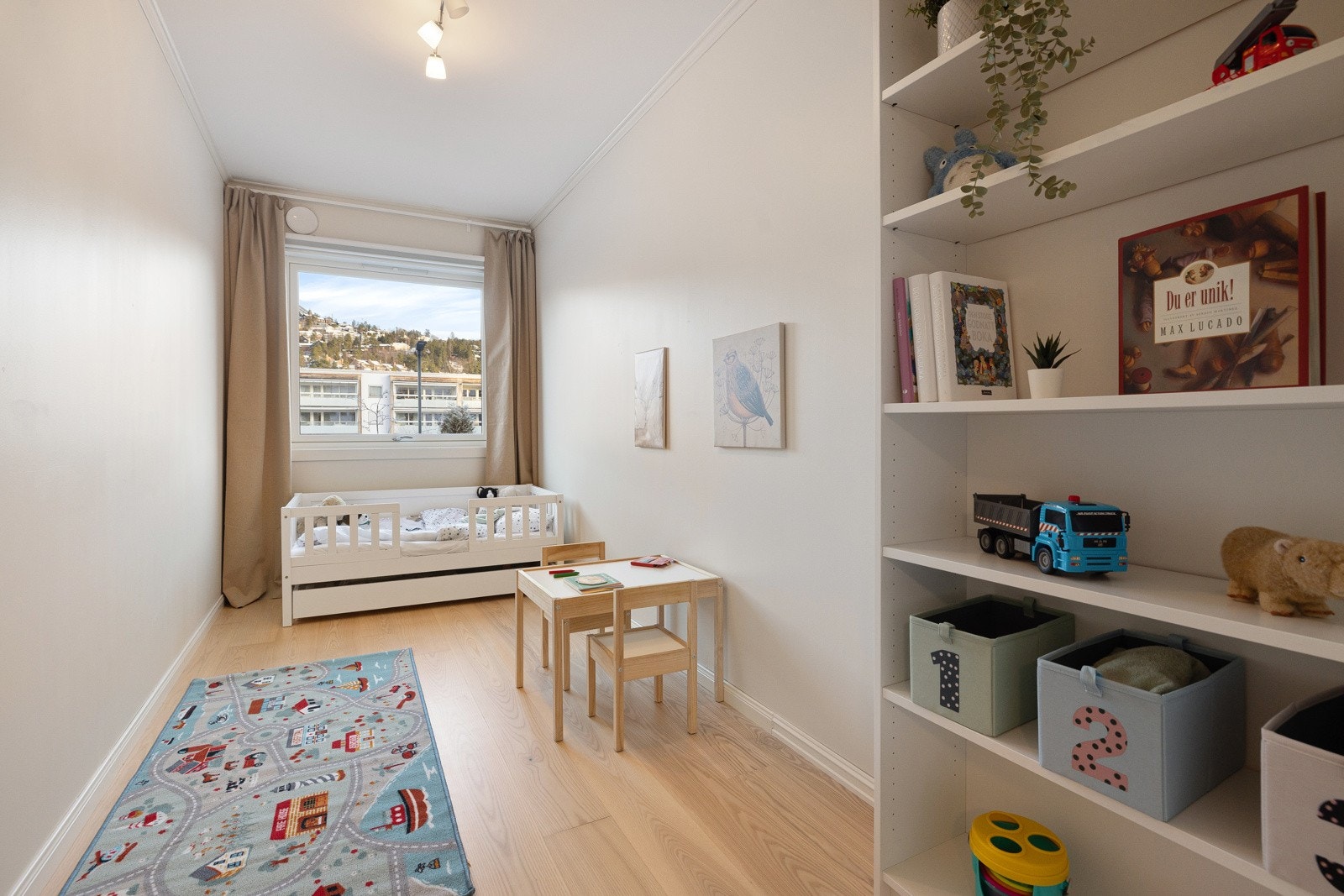 Lyst og innbydende soverom som passer perfekt som barnerom eller gjesterom. Her er det plass til både seng, oppbevaring og lek. Galleribilde
