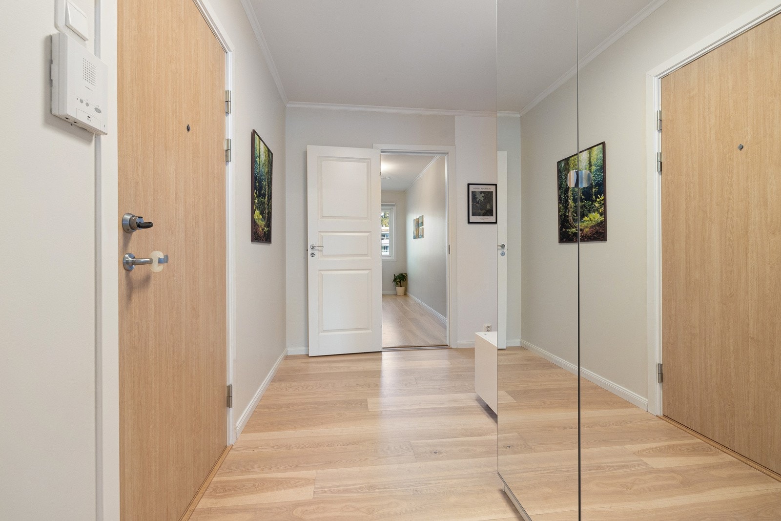 Entréen gir et flott førsteinntrykk av boligen med lyse overflater og parkettgulv. Galleribilde