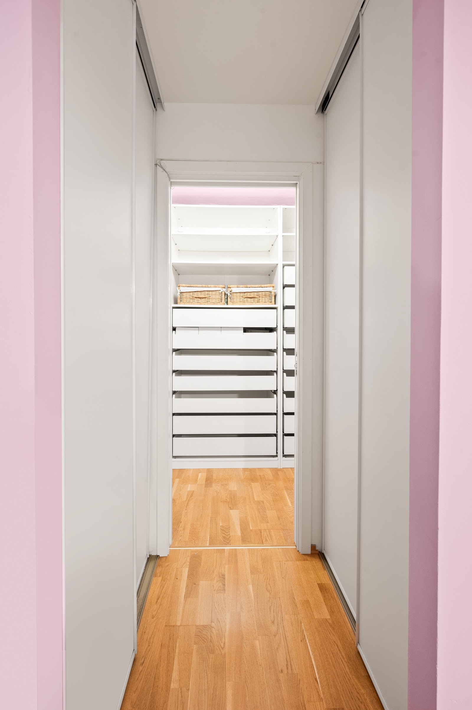 Romslig walk-in closet inndelt i to soner hvorav en er innredet med skyvedørsgarderobe på hver side. Galleribilde