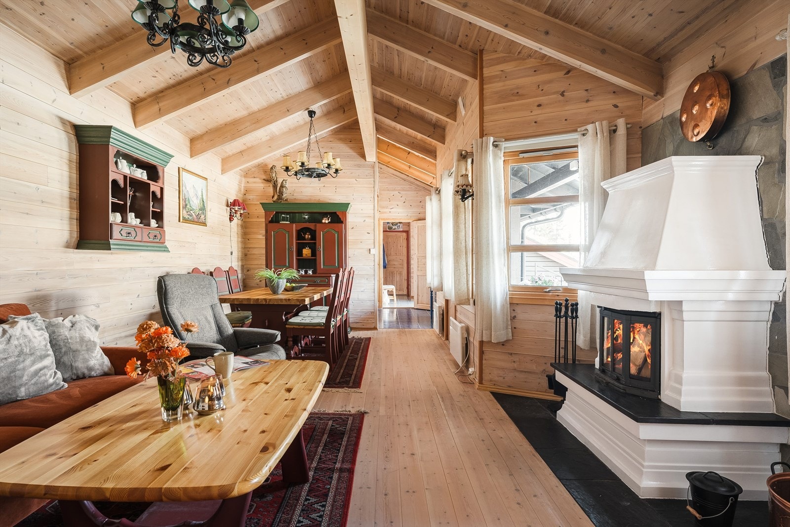 Den lyse og trivelige stua har et samstemt og pent preg med tregulv og trepanel på vegger og i tak. Merk forøvrig alle vinduene som gir fint utsyn og ikke minst en lys og fin atmosfære. Alle vinduer med rullegardiner. Galleribilde