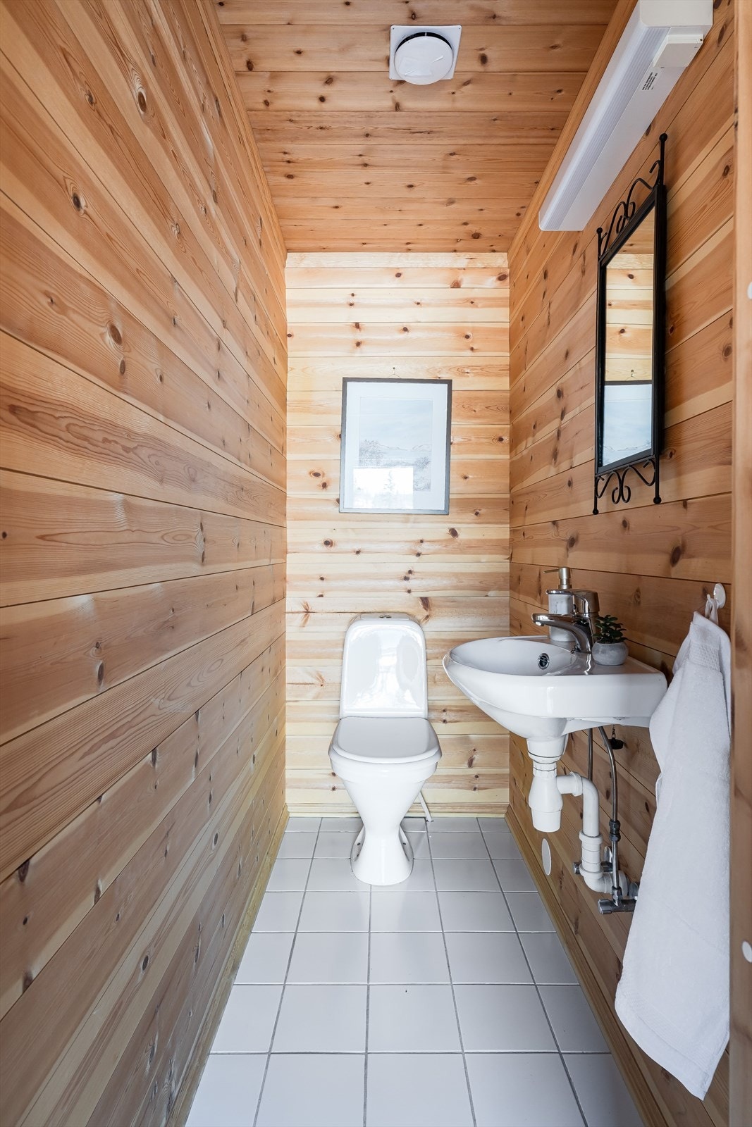 Praktisk og separat toalettrom vegg-i-vegg med badet. Her er det wc og vegghengt servant med belysning over. Også dette rommet med varme i gulvet. Galleribilde