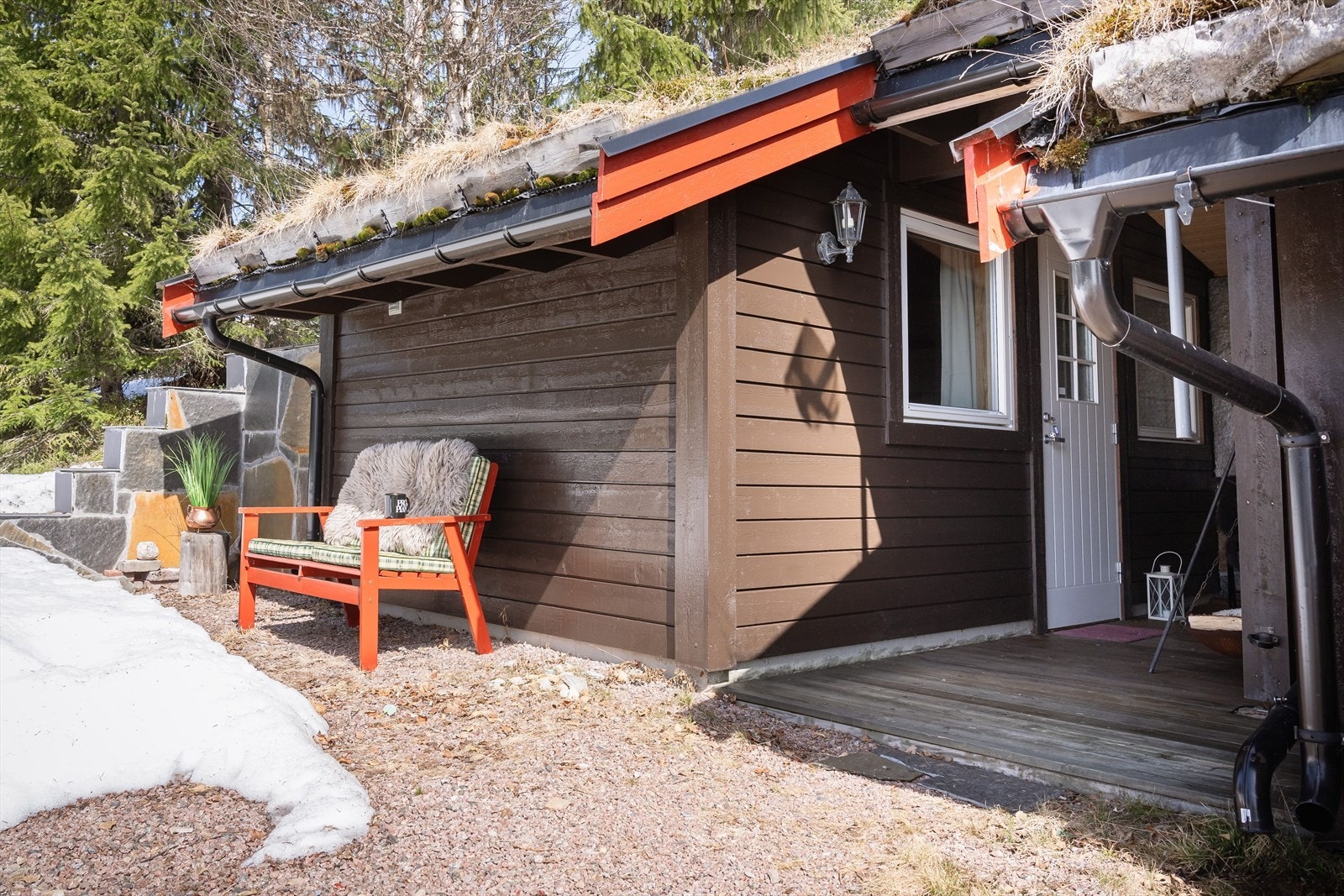 Inntilbygd anneks er isolert og har adkomst via overbygd terrasseplatting. Merk den fine leveggen på enden kledd i naturstein. Galleribilde
