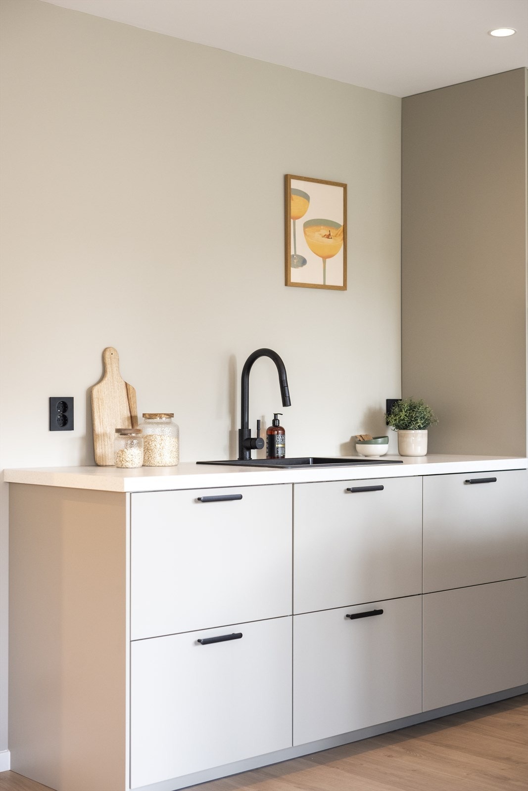 Lys innredning med glatte fronter og benkeplate med nedfelt vask. Galleribilde