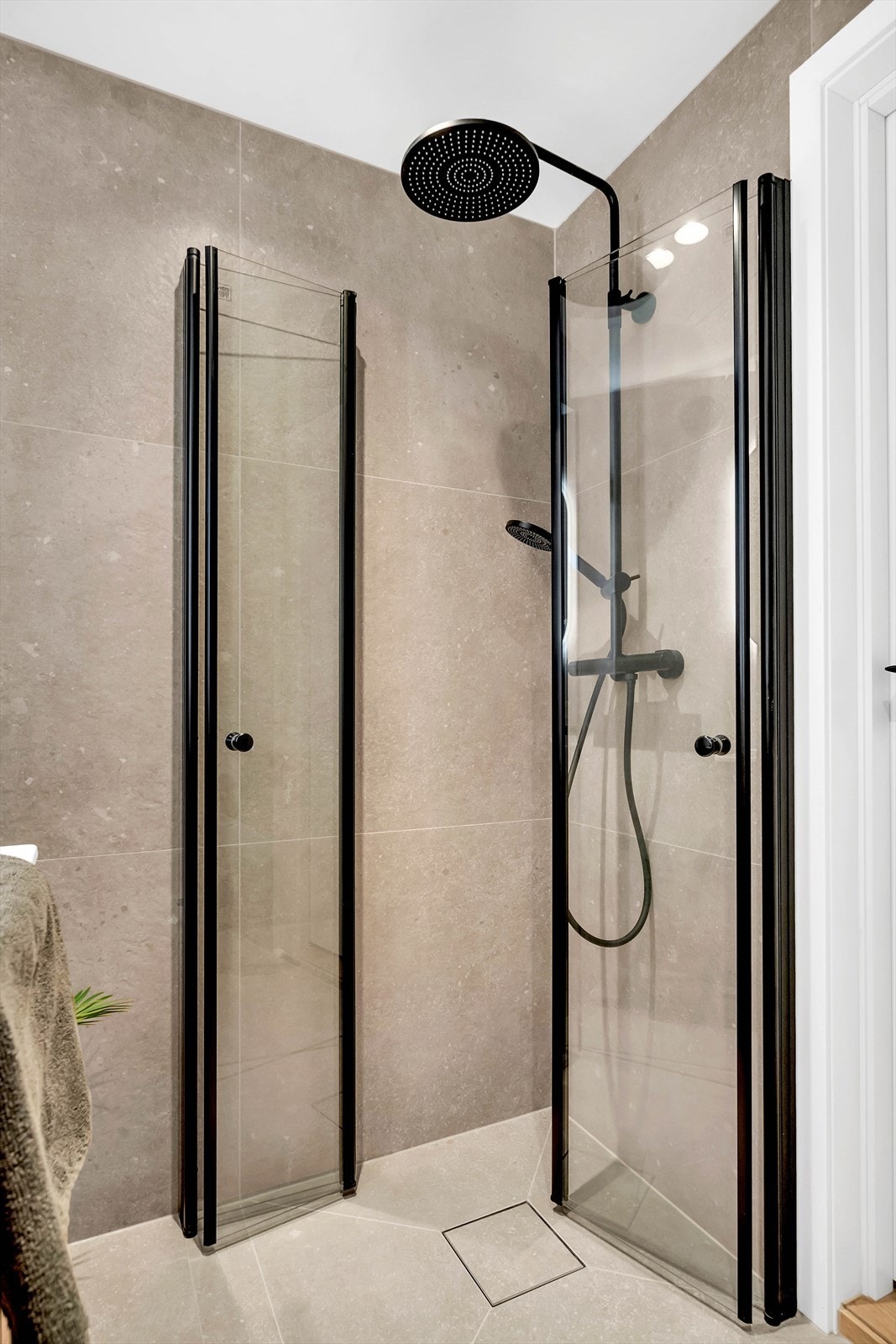 Badet er innredet med vegghengt toalett, servant nedfelt i innredning, speil med belysning og dusjhjørne med foldbare glassdører. Galleribilde