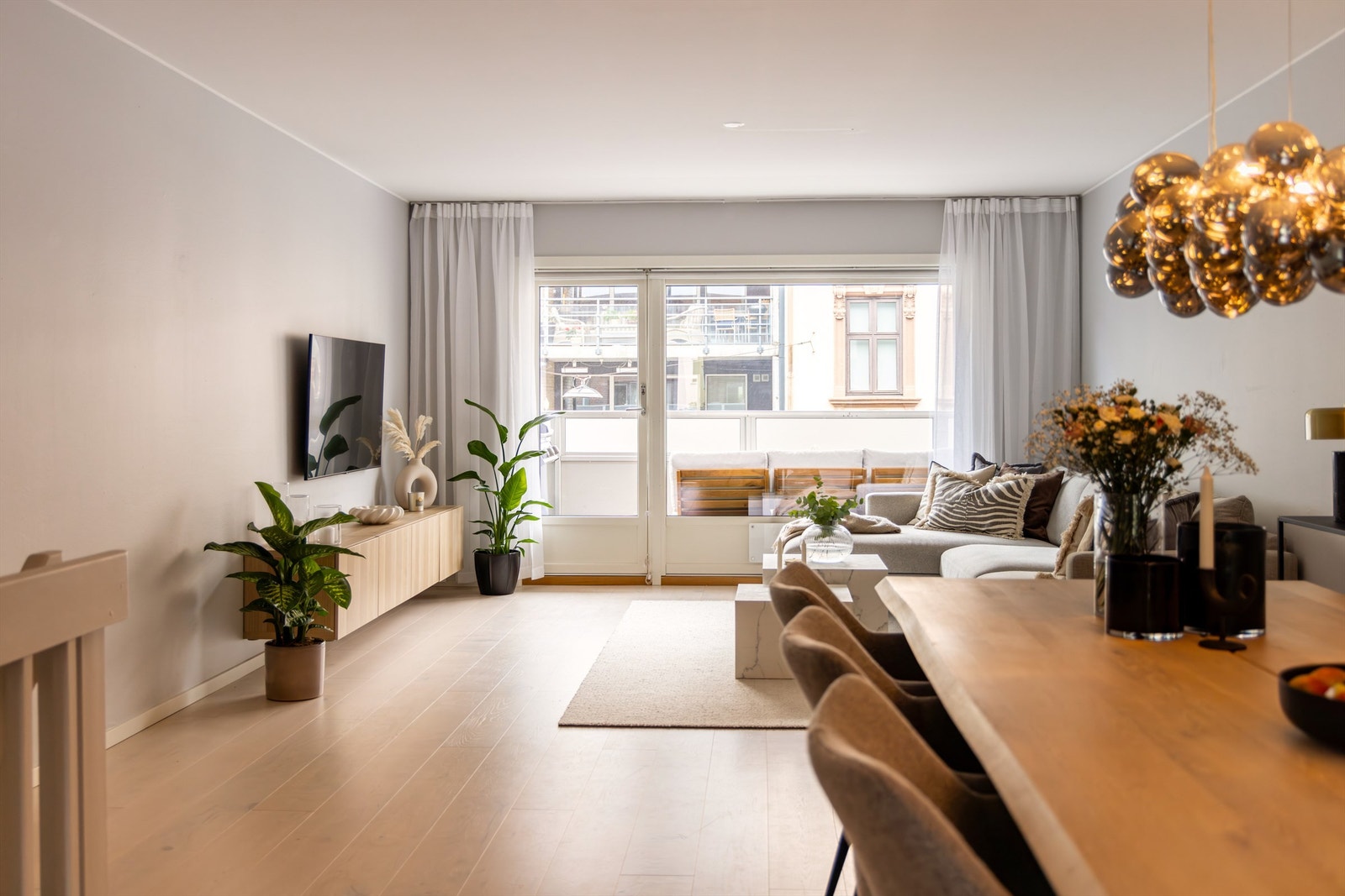 Lys og romslig stue med naturlig sofa-/tv- og spisesone. Galleribilde