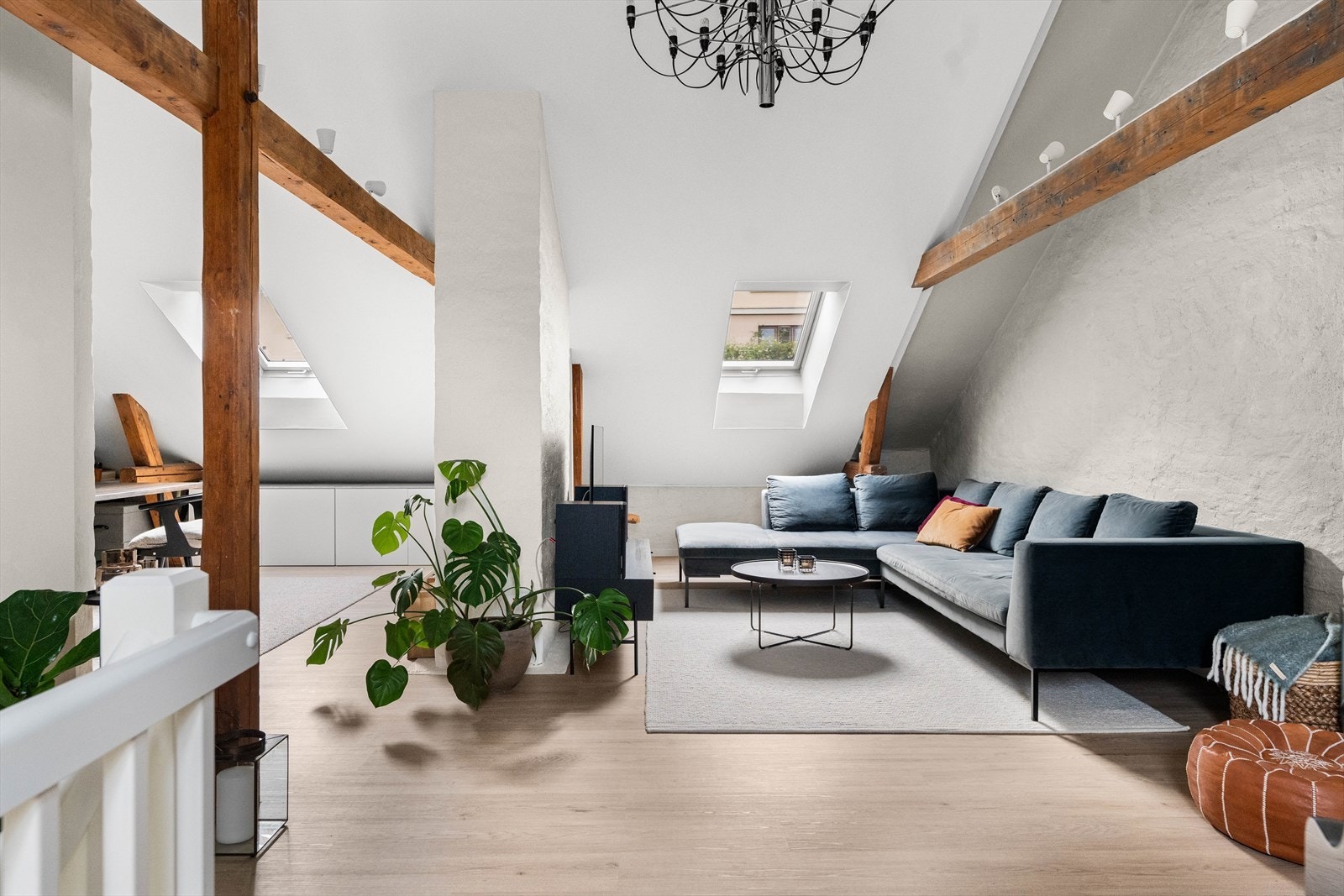 Fra trappen kommer man opp i en lys loftstue med flotte detaljer i takbjelkene fra 1800-tallet Galleribilde