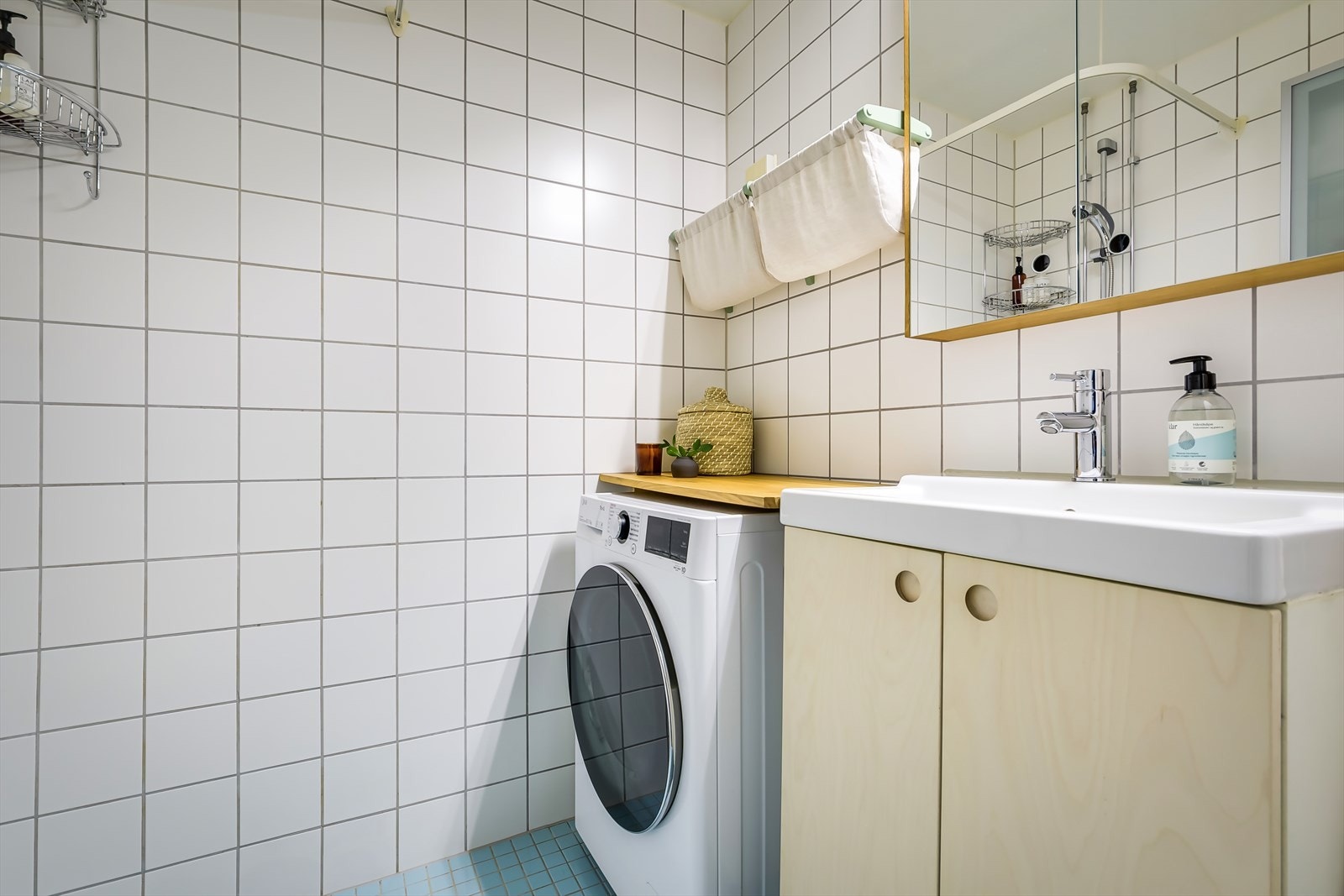 Badet er innredet med servant med underskap, overskap med speildører og lys, overskap med glassdør, frittstående toalett og dusjhjørne med forheng. Galleribilde