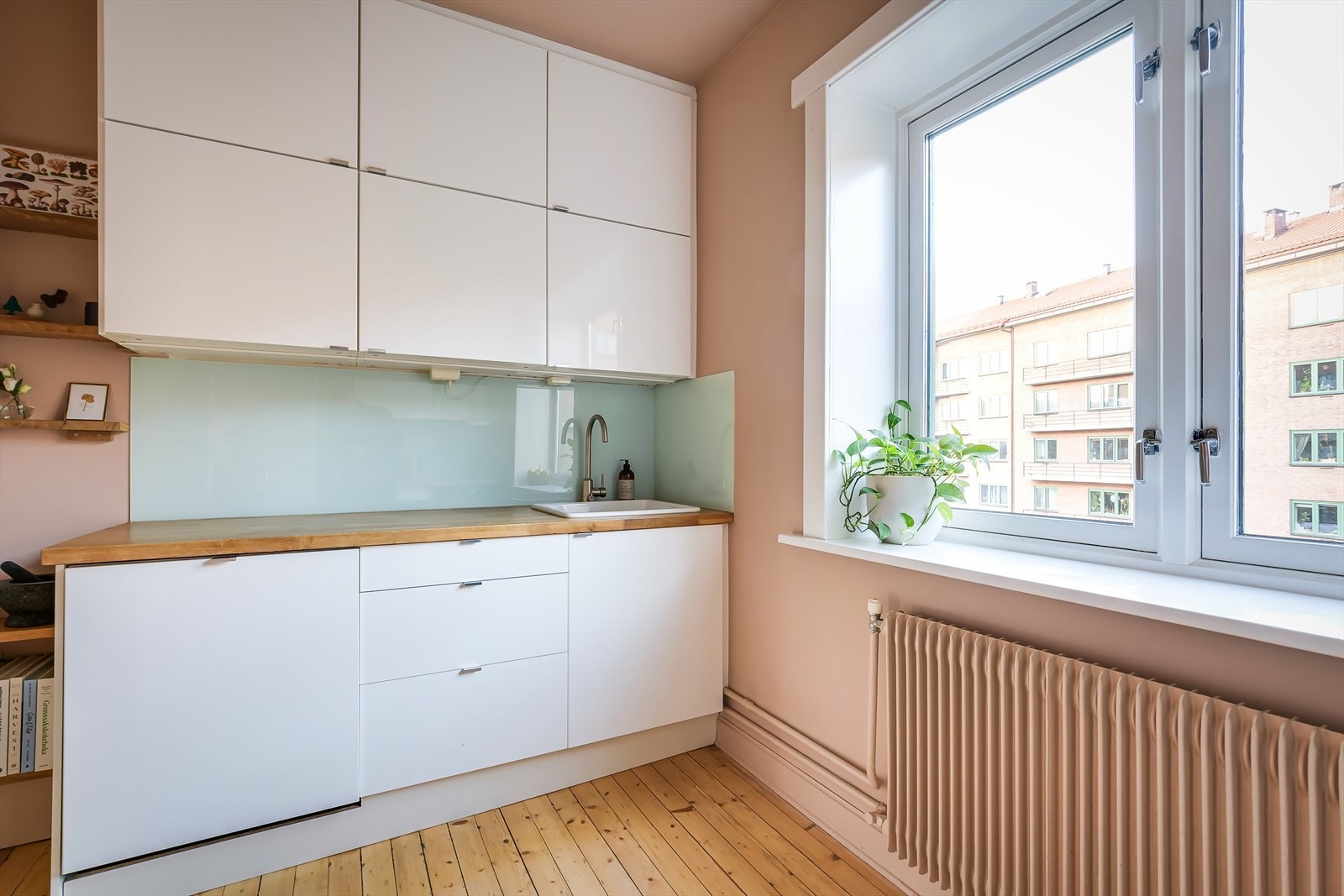 Innredningen er fra IKEA og har slette høyglansfronter, heltre benkeplate med glassplater på bakvegg og enkel oppvaskkum. Galleribilde