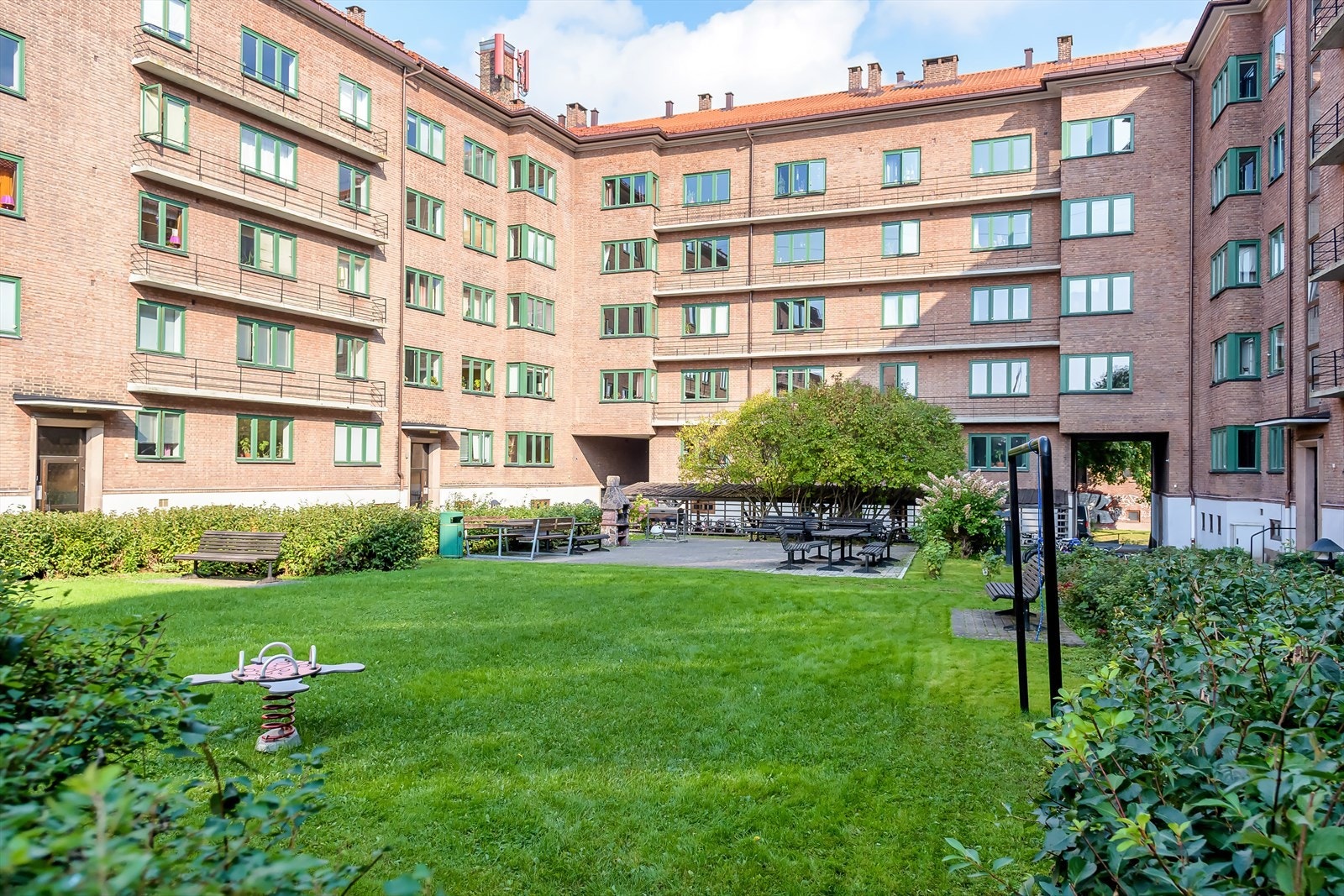 Borettslaget har en herlig, parkmessig bakgård med frodig beplantning, lekeapparater for barna og grillområde med sittegrupper. Galleribilde